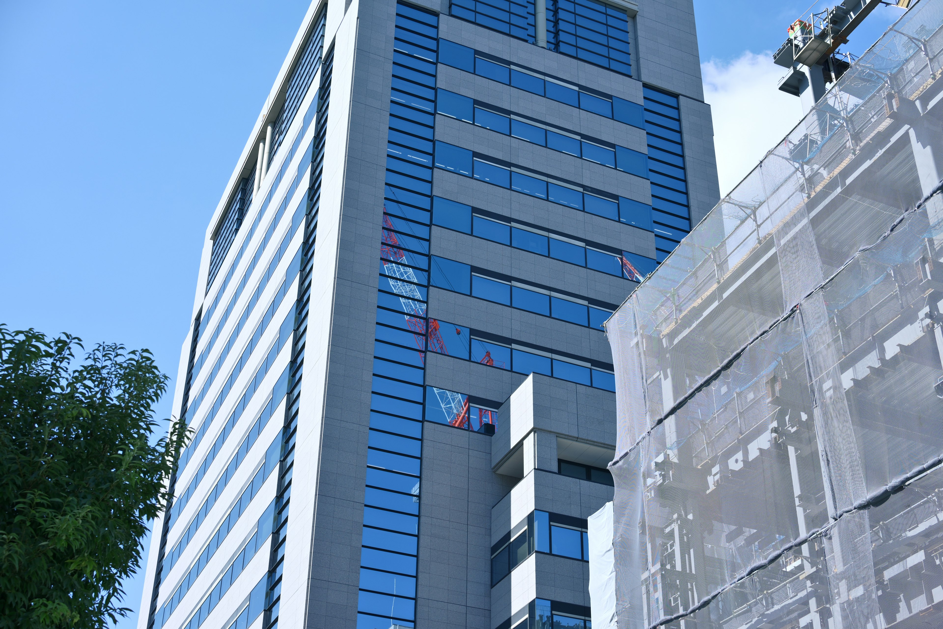 Extérieur d'un bâtiment moderne sous un ciel bleu avec des fenêtres réfléchissantes