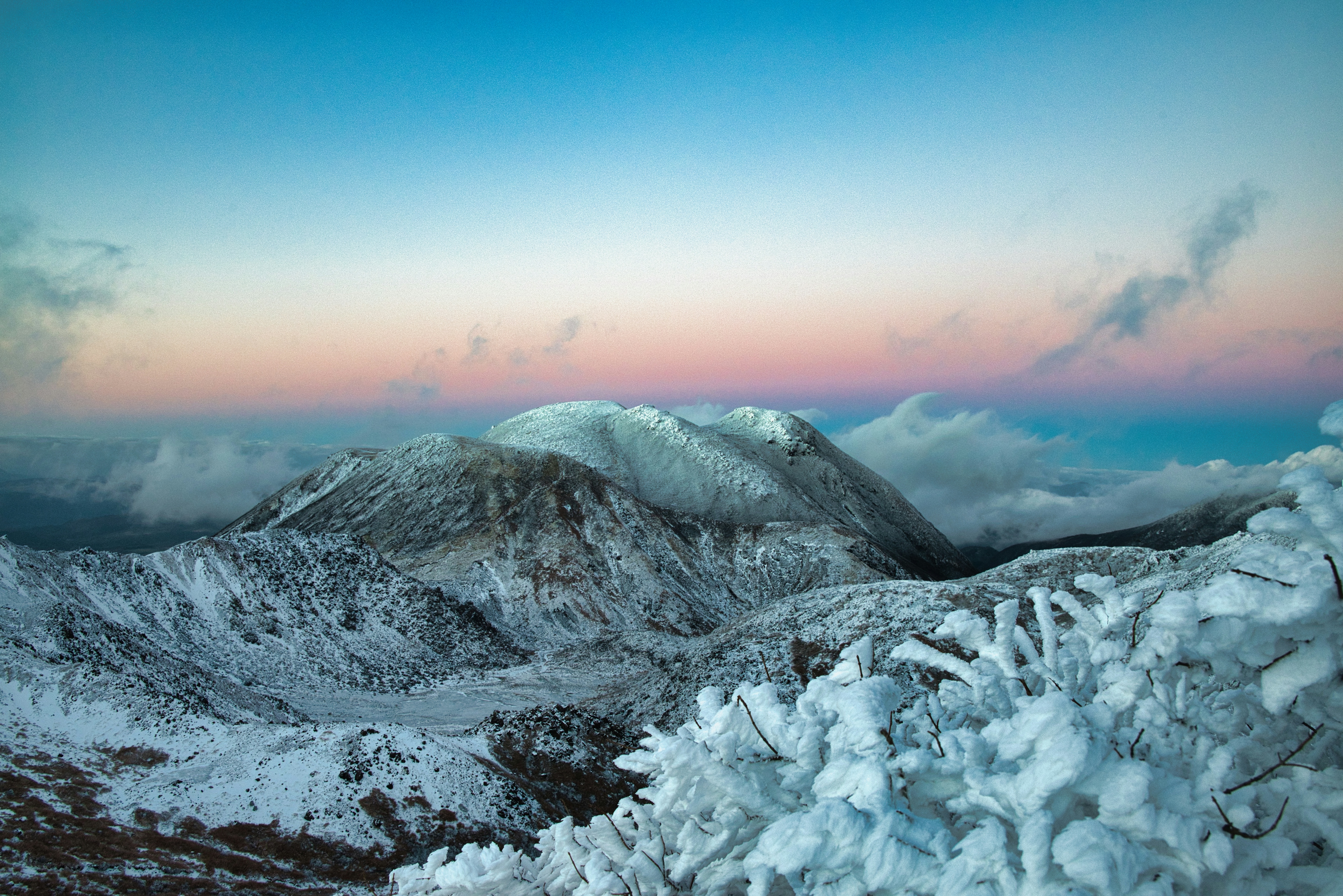 Montagne innevate con un cielo blu sfumato