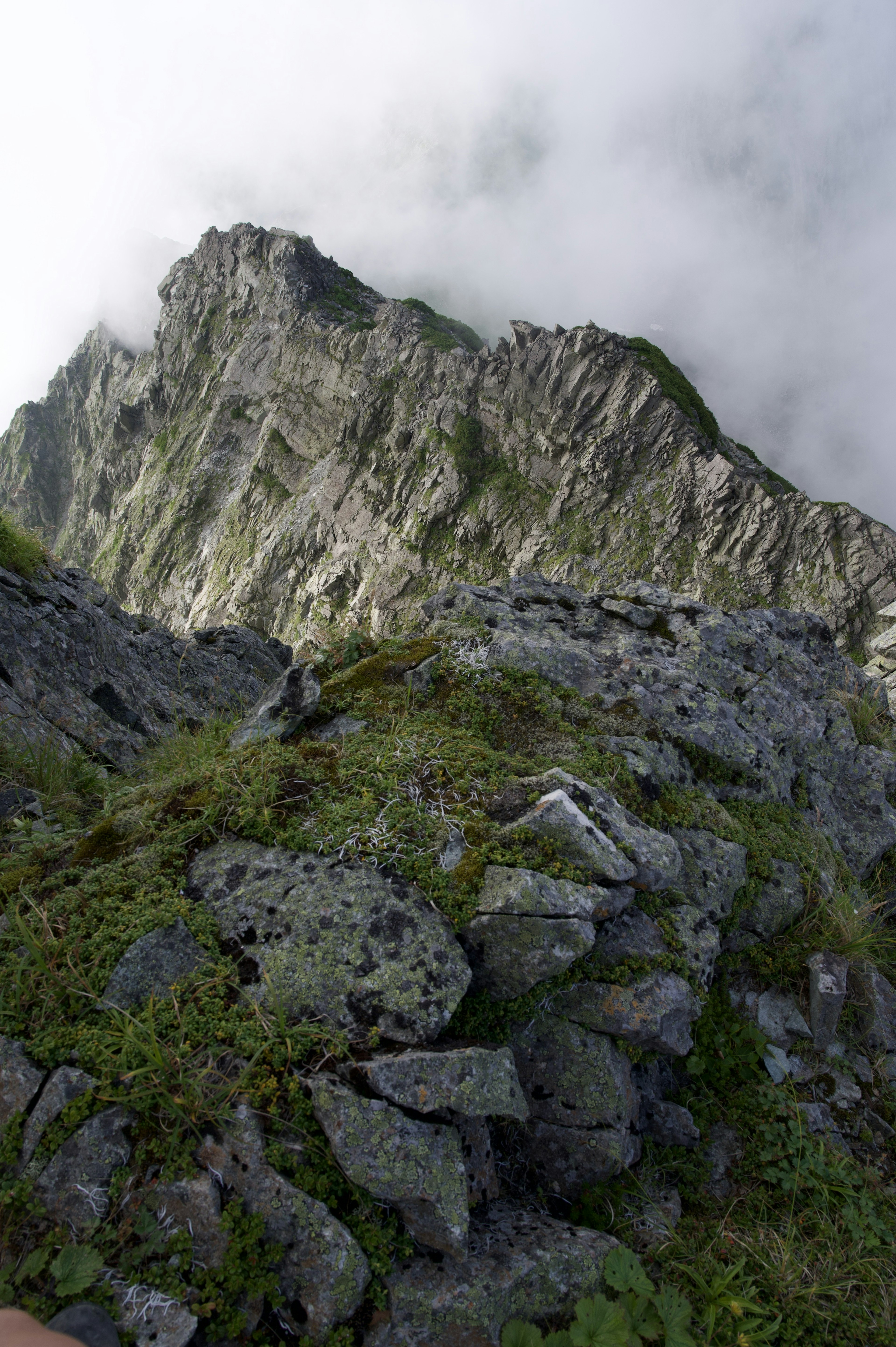 Berggipfel in Wolken gehüllt mit detailliertem felsigem Gelände