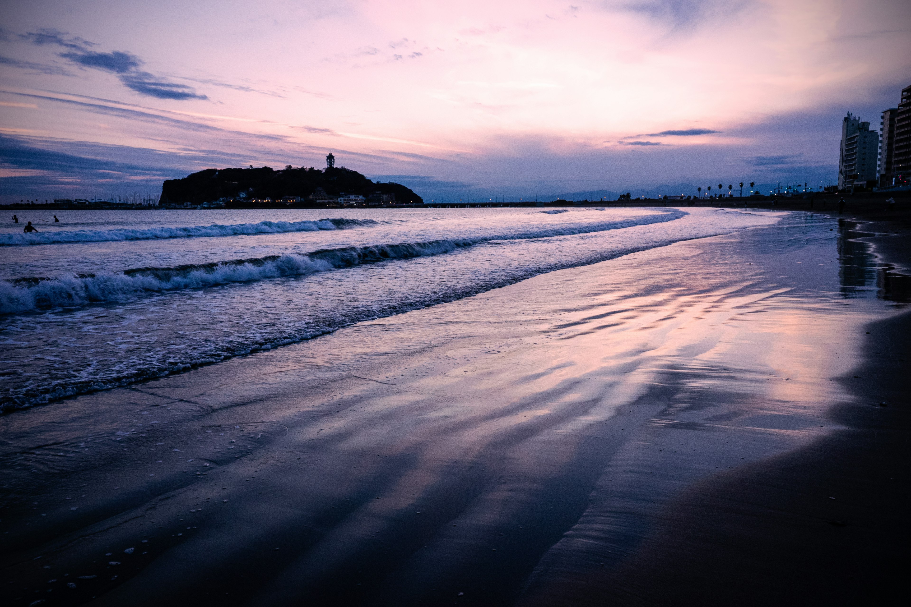 夕暮れ時の海岸線と波の反射が美しい風景