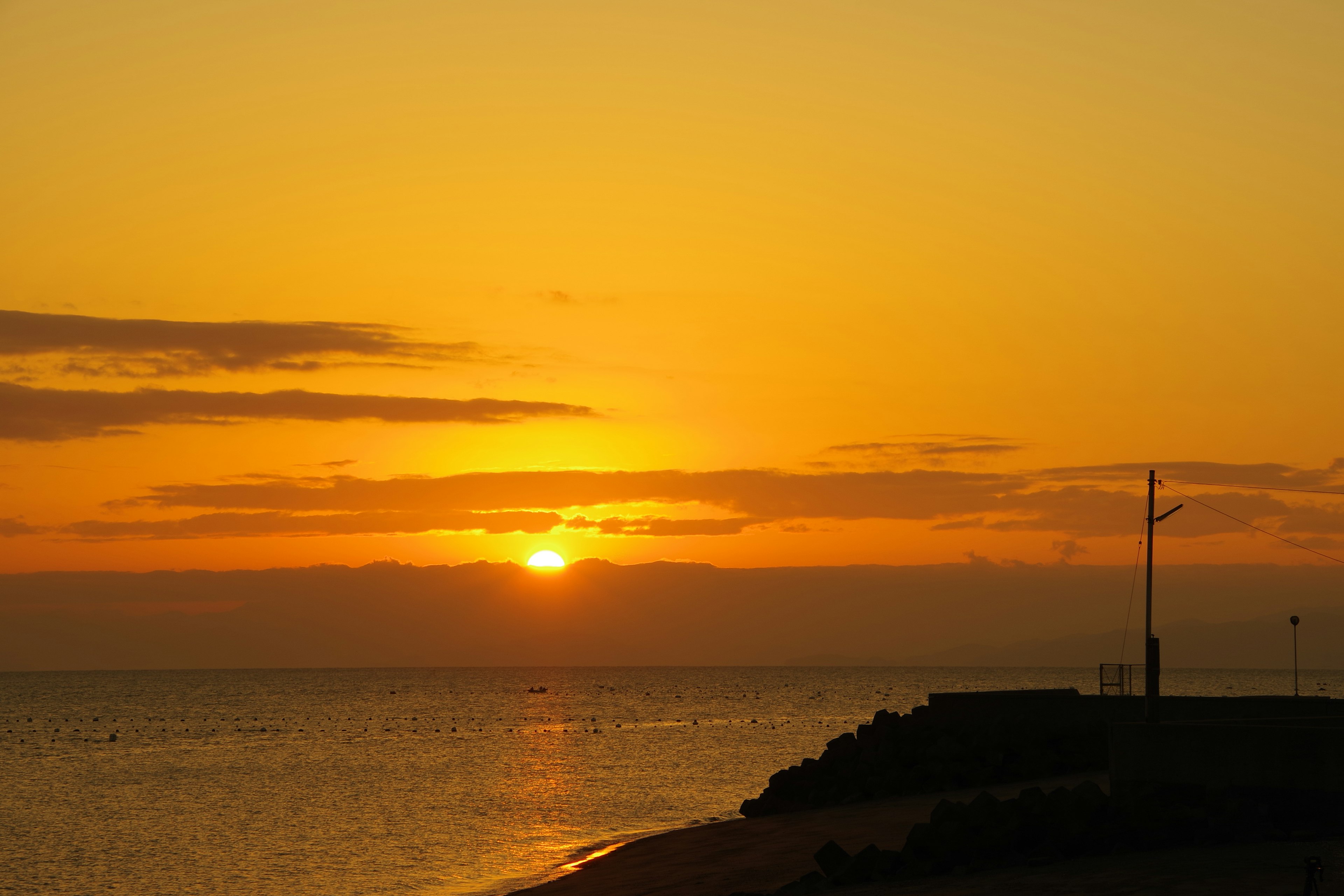 Ein schöner orangefarbener Sonnenuntergang über dem Meer