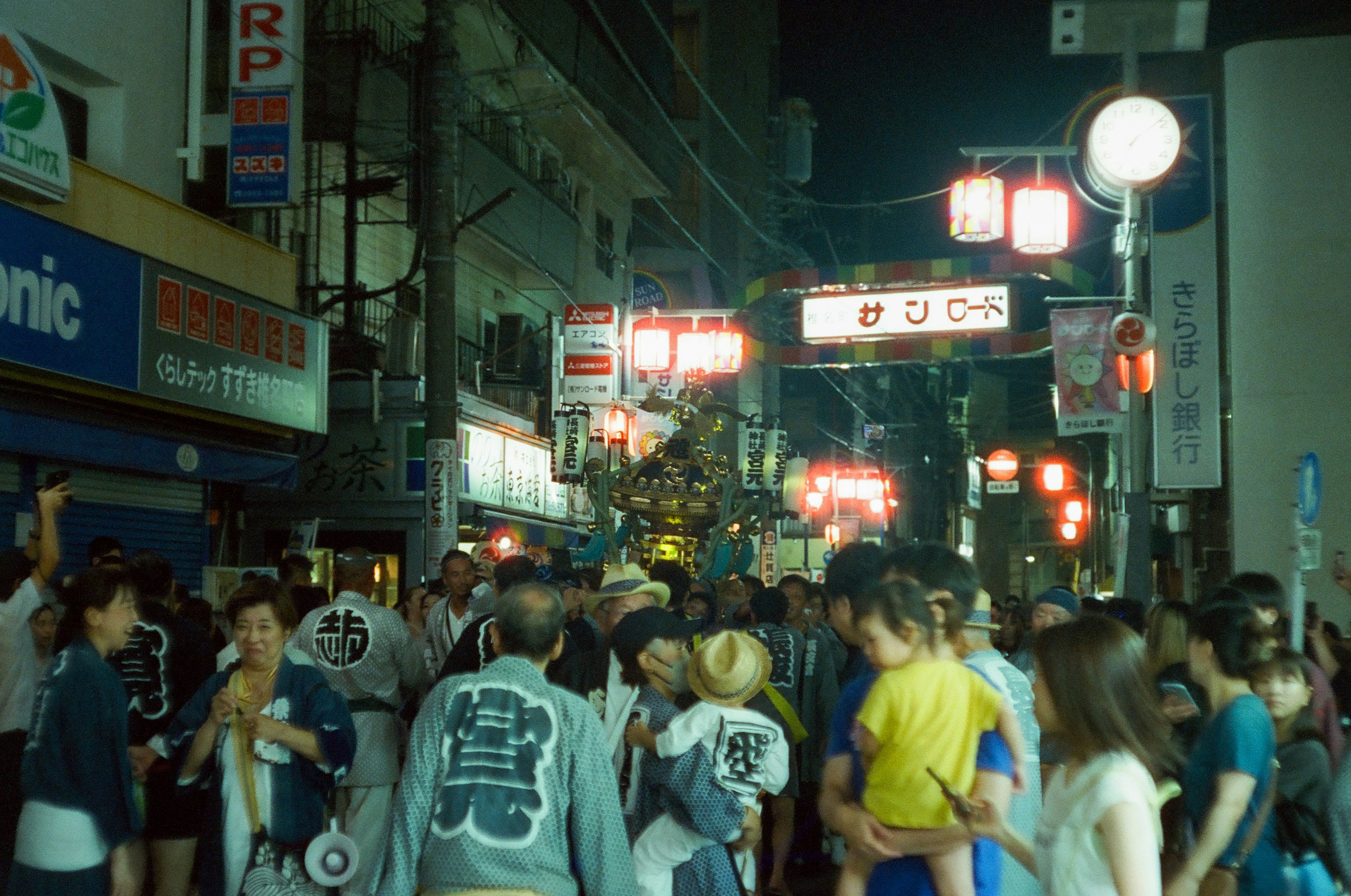 夜の街並みで賑わう人々と提灯の光