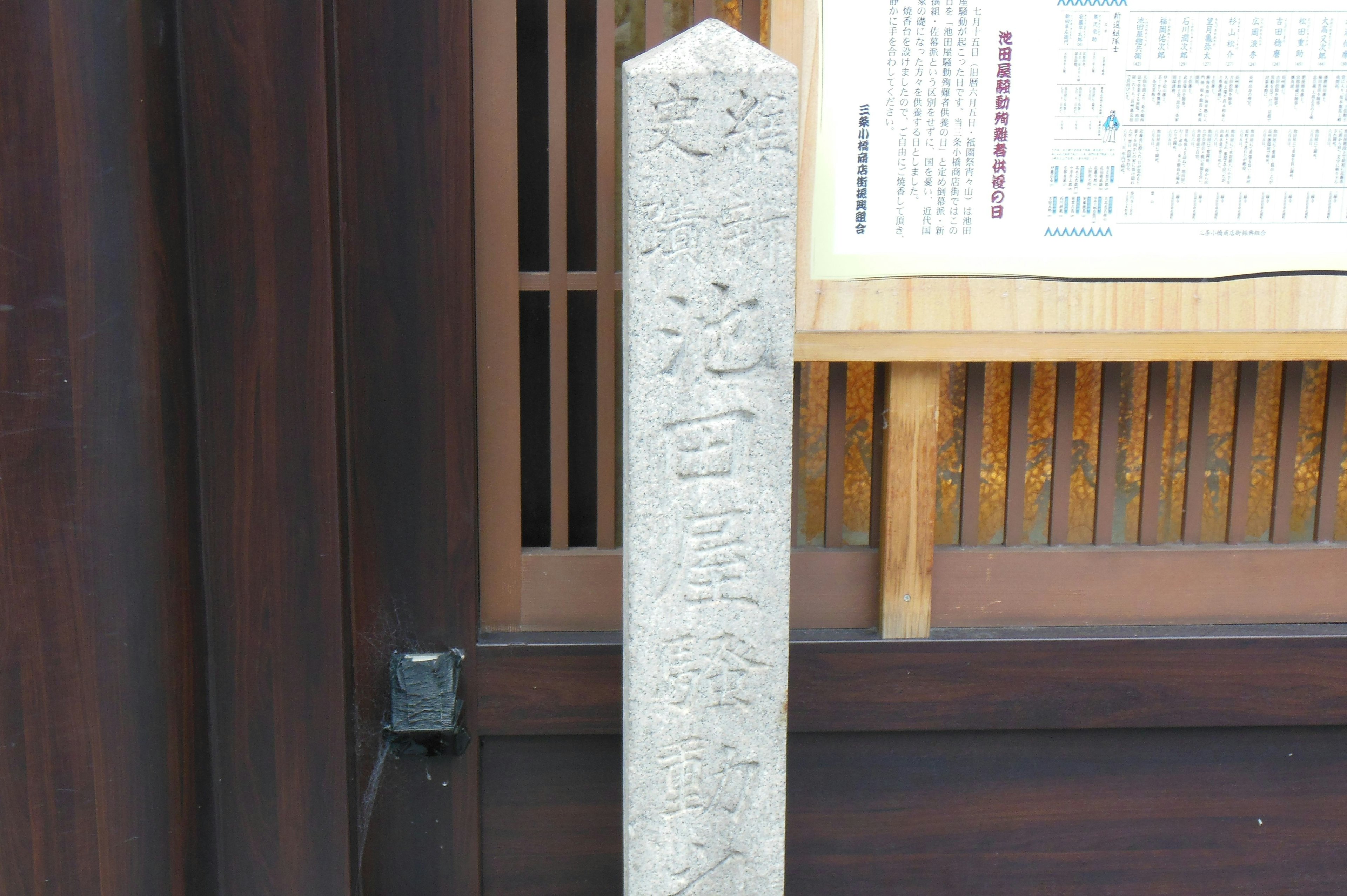 An old stone marker stands beside a wooden door