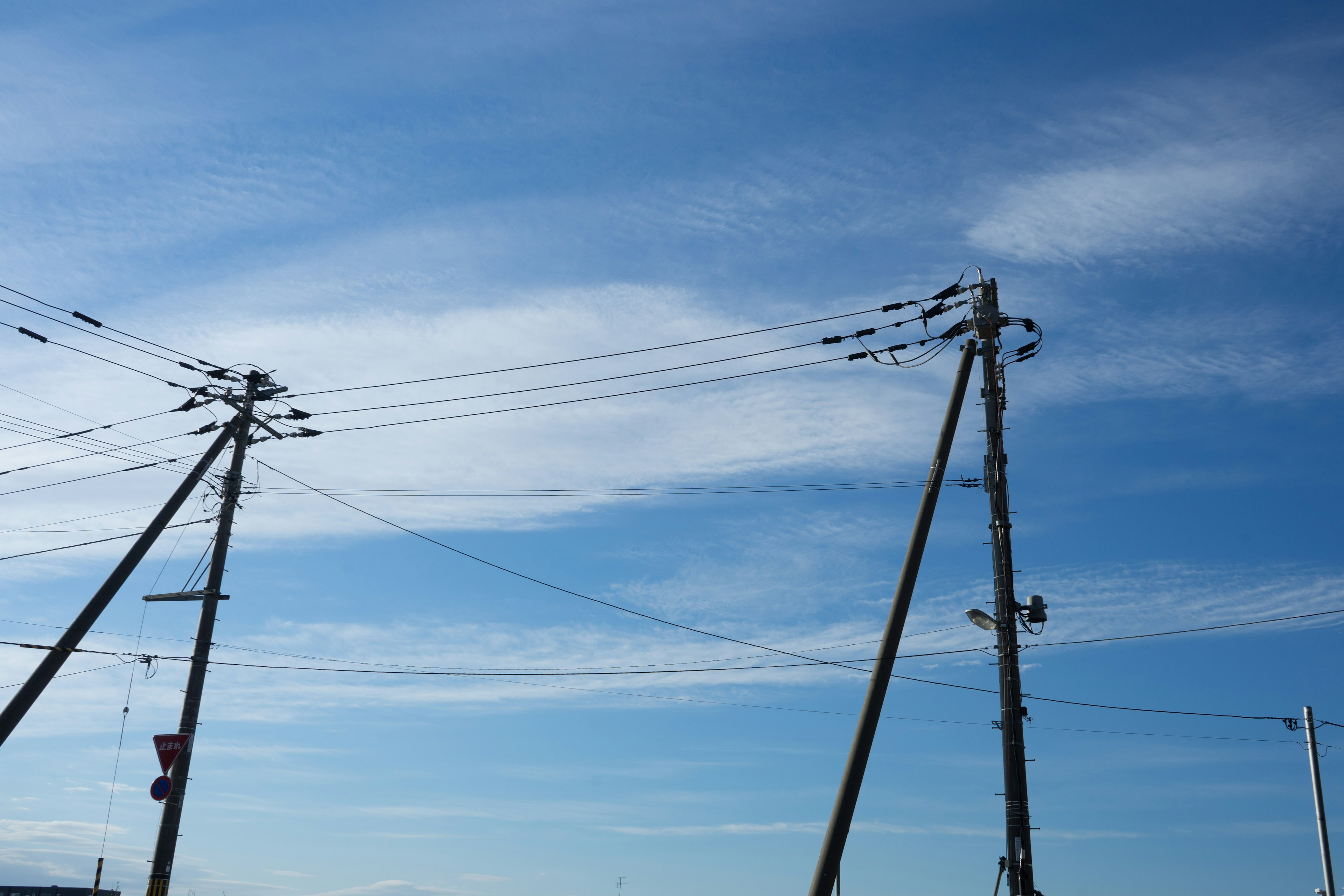 Escena de cielo azul con postes eléctricos