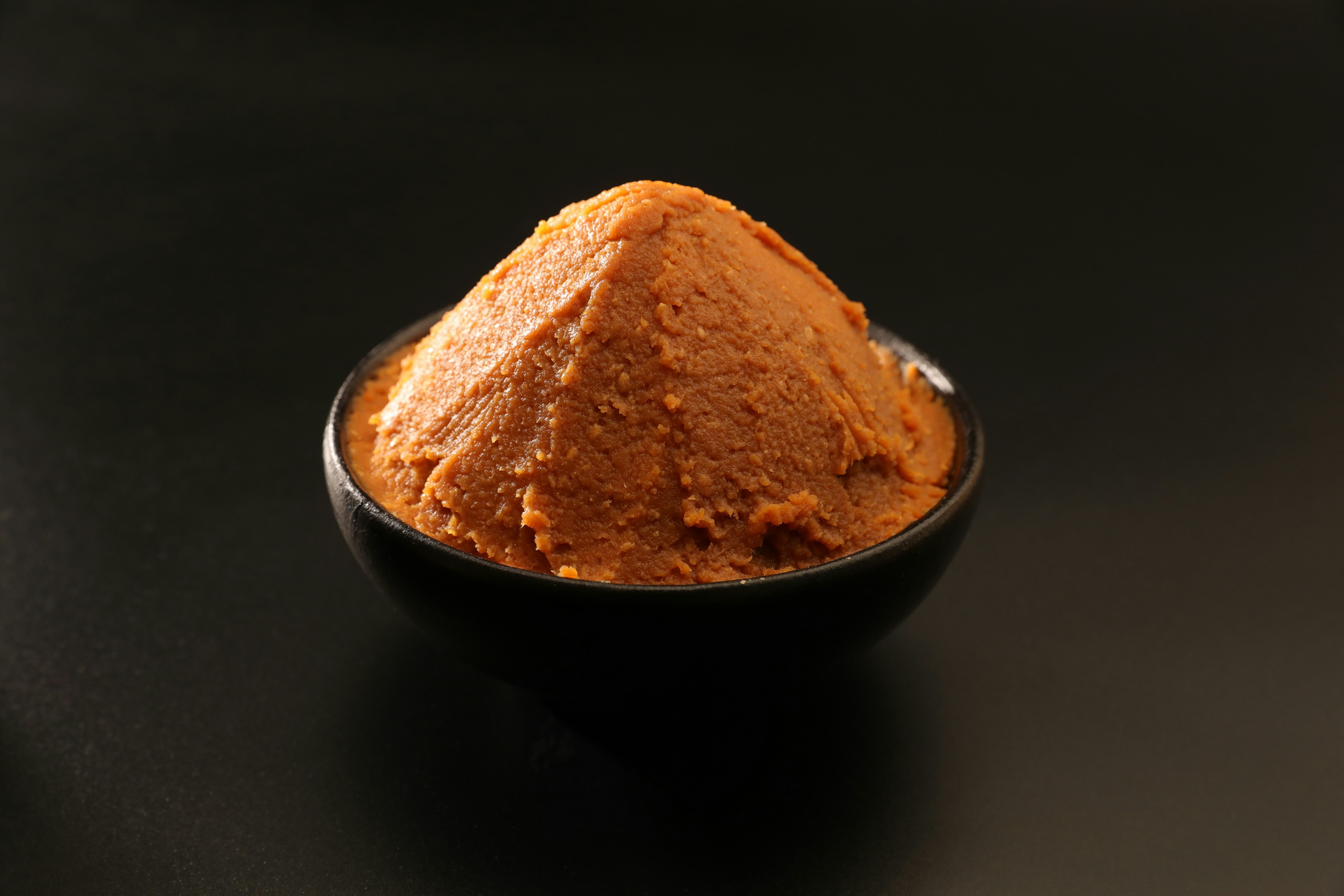 A mound of brown seasoning on a black background