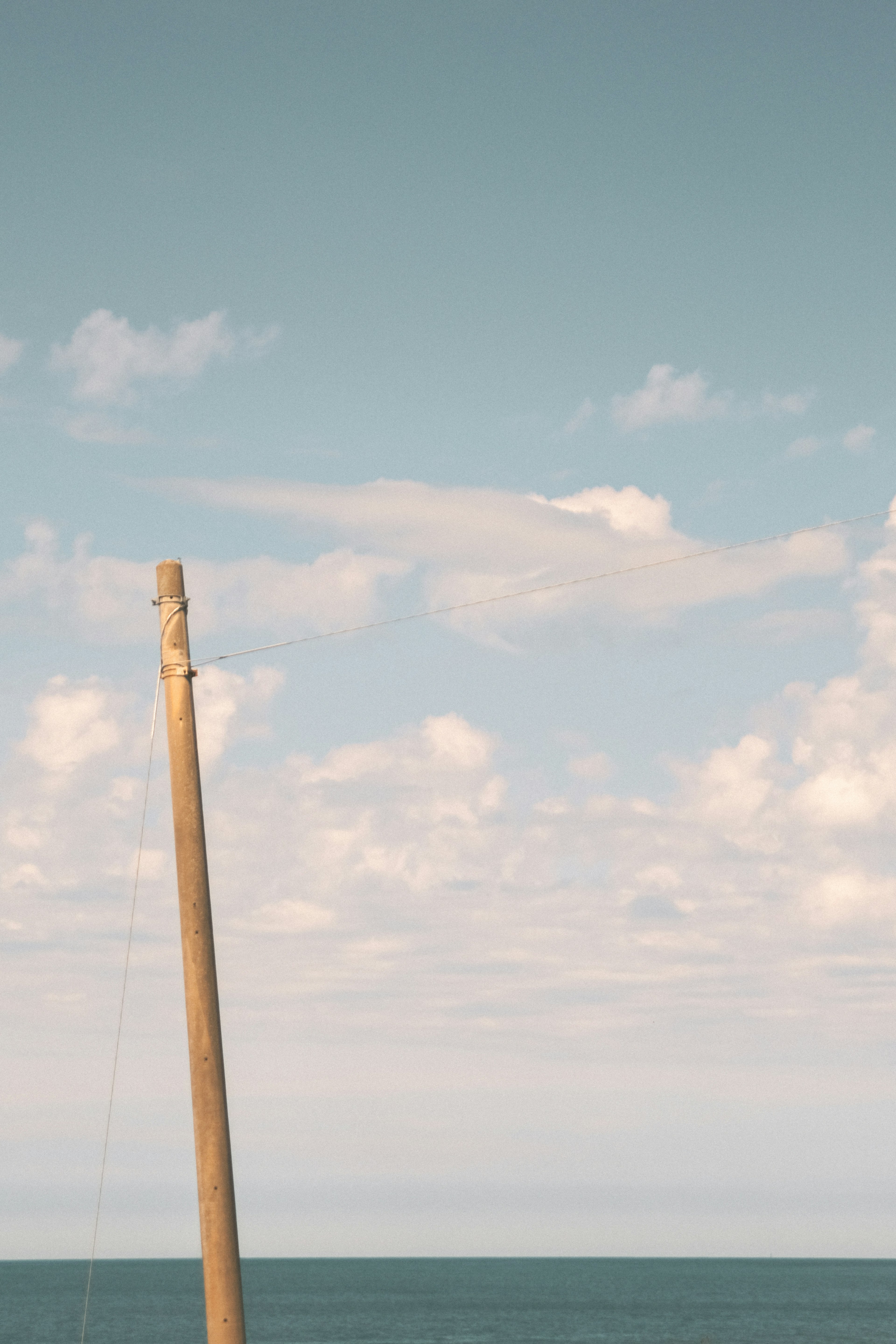 Wooden pole against a backdrop of blue sea and sky