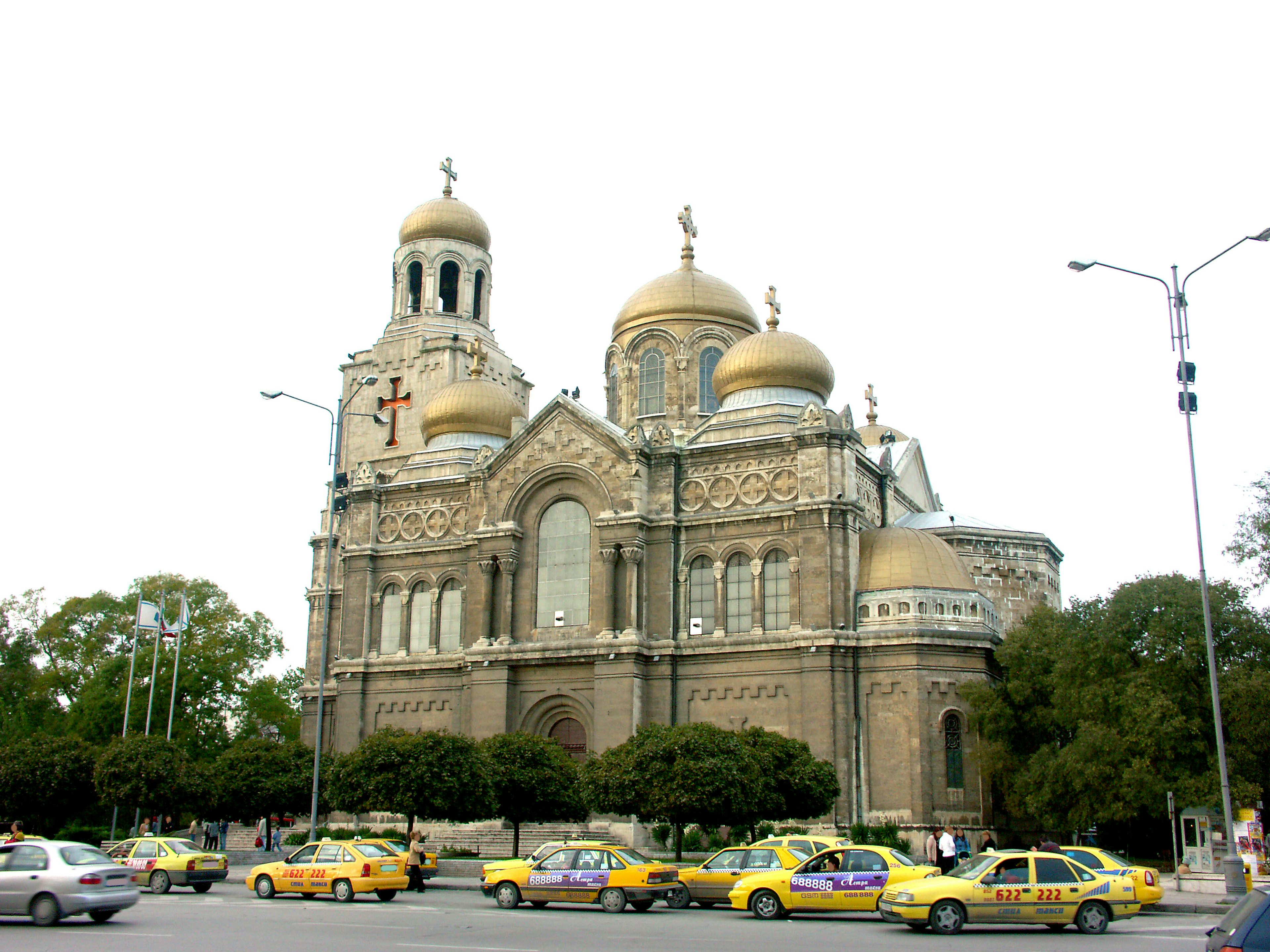 Church with golden domes and yellow taxis in the foreground