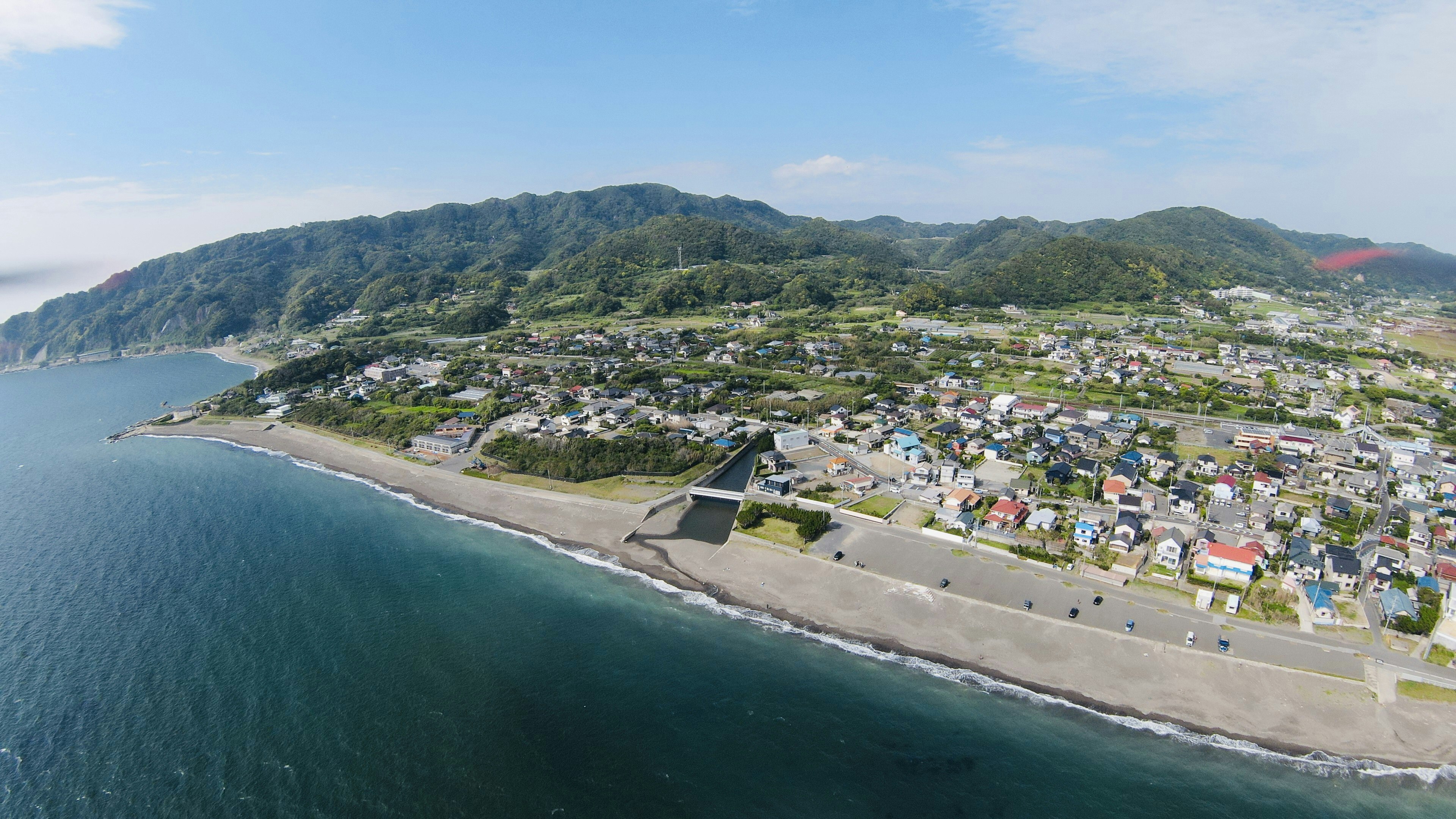 Aerial view of a coastal town with mountains in the background