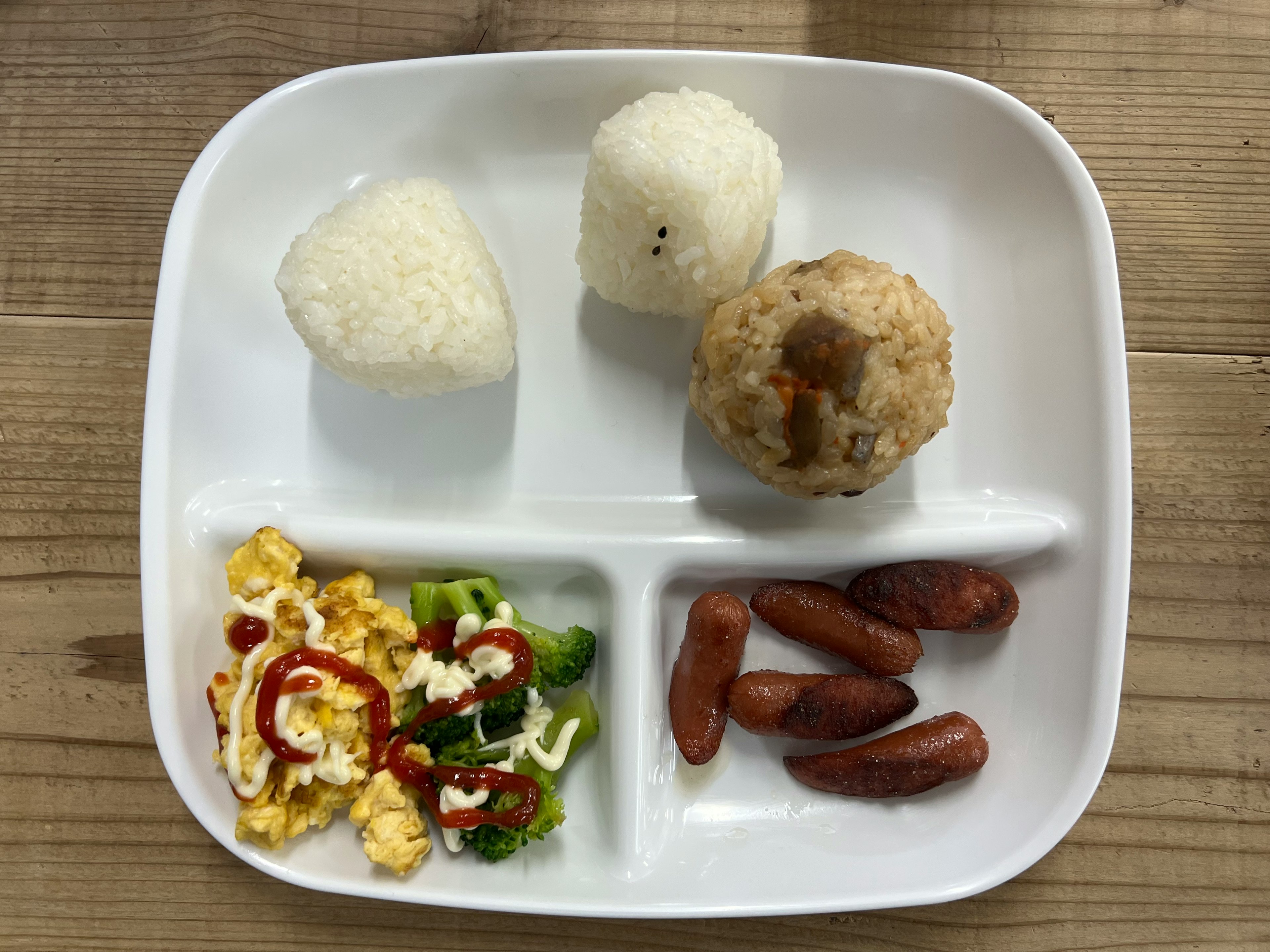 Une assiette avec des boules de riz et des plats d'accompagnement variés