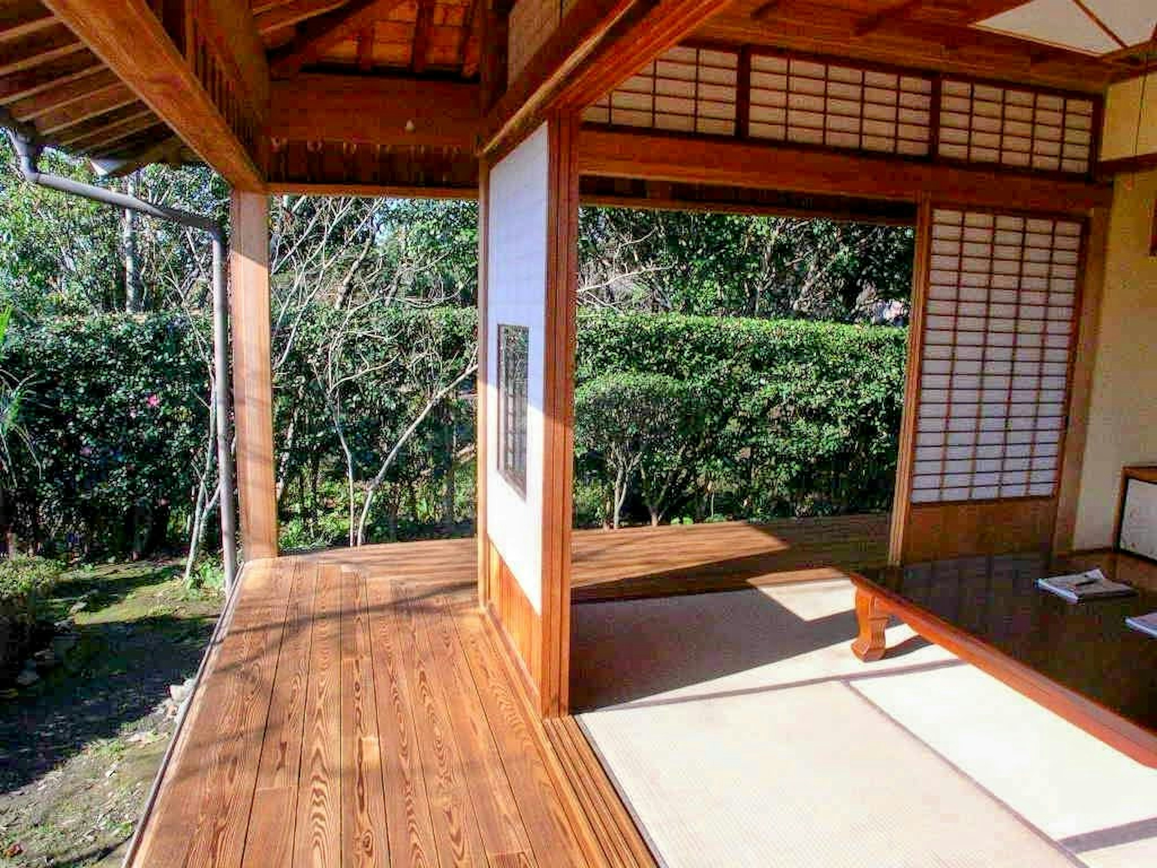 Vista interior de una habitación japonesa tradicional con terraza de madera y tatamis