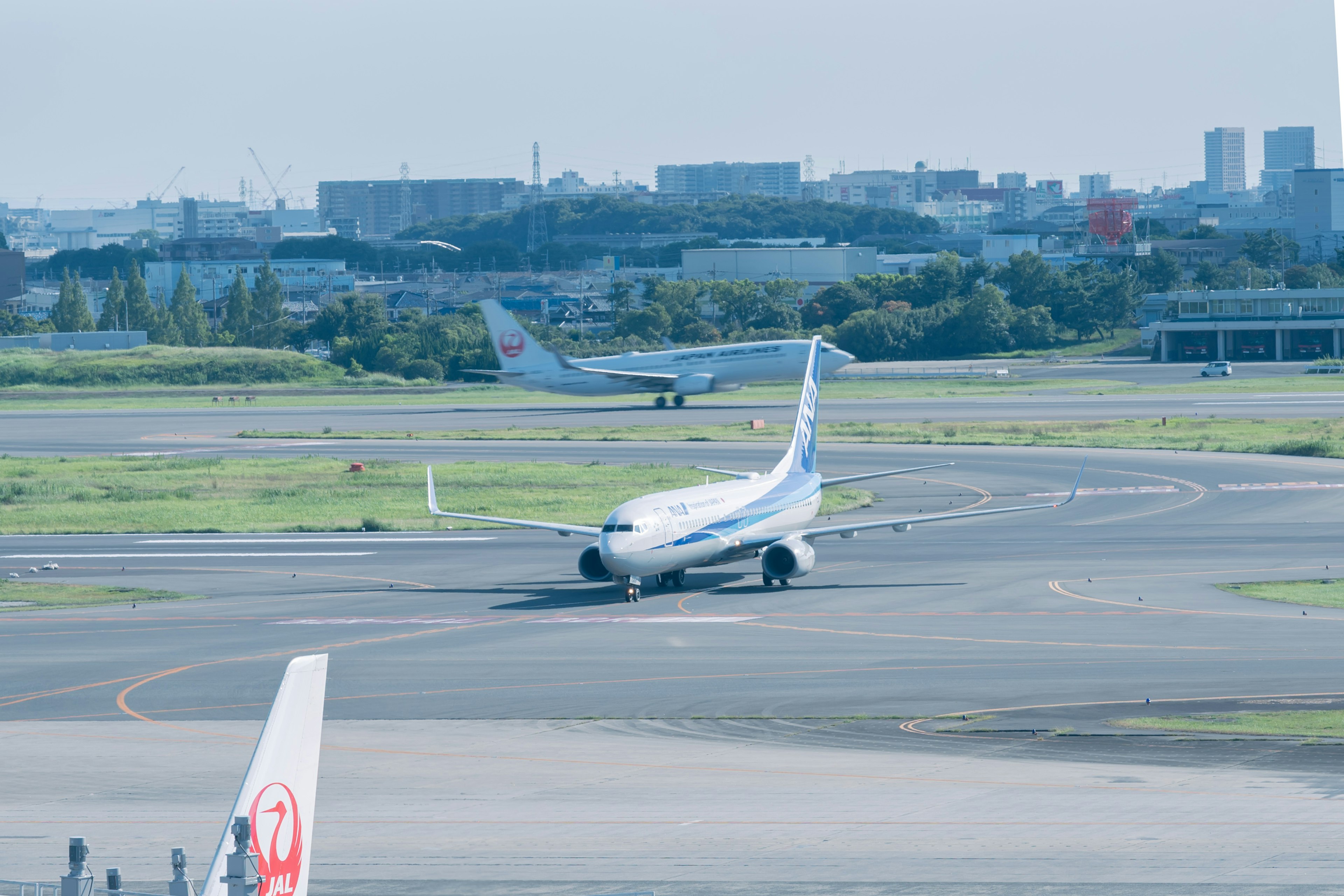 Flugzeug, das auf der Landebahn rollt, mit einem anderen Flugzeug im Hintergrund