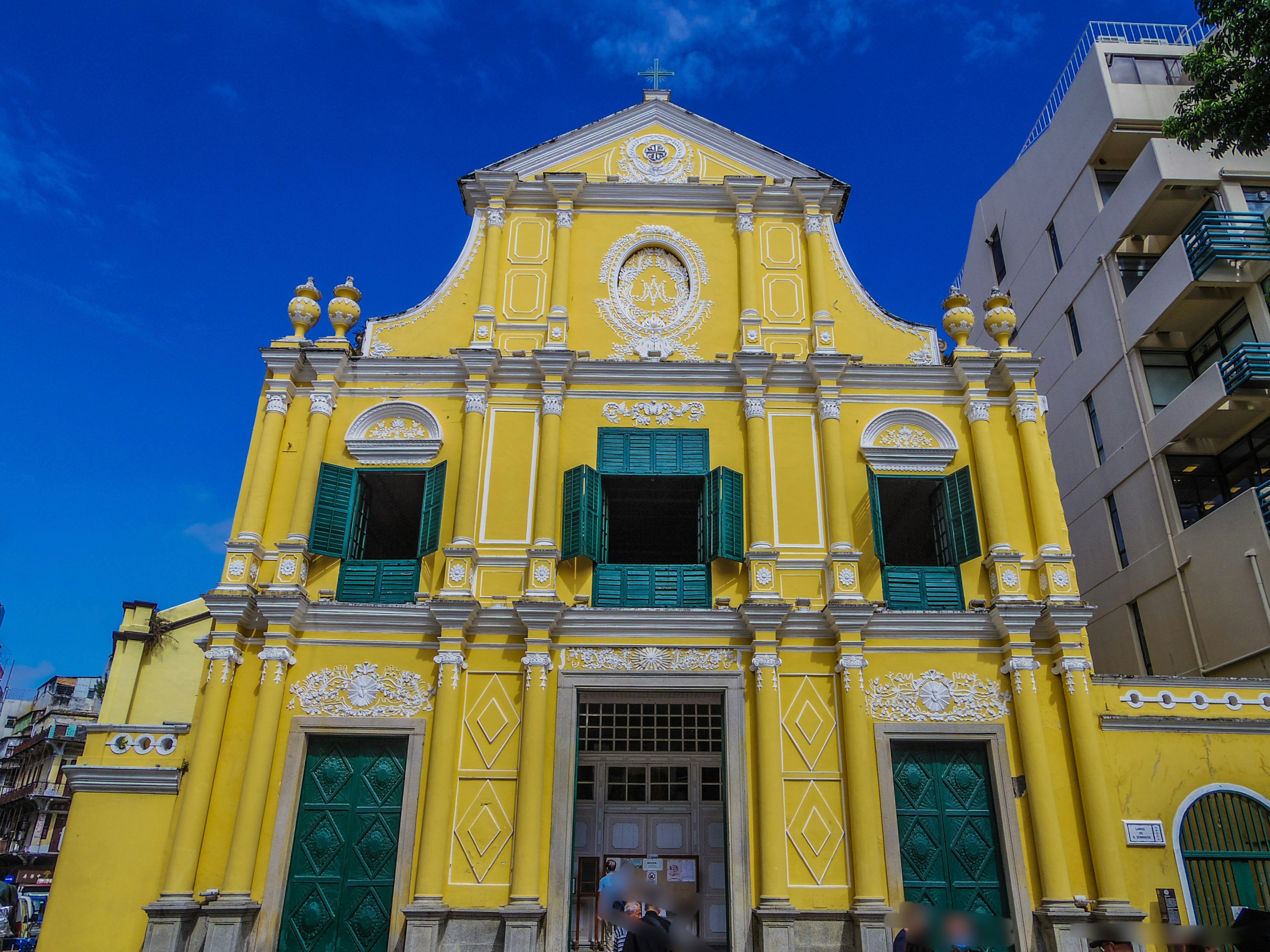 Bâtiment historique avec une façade jaune et des fenêtres vertes