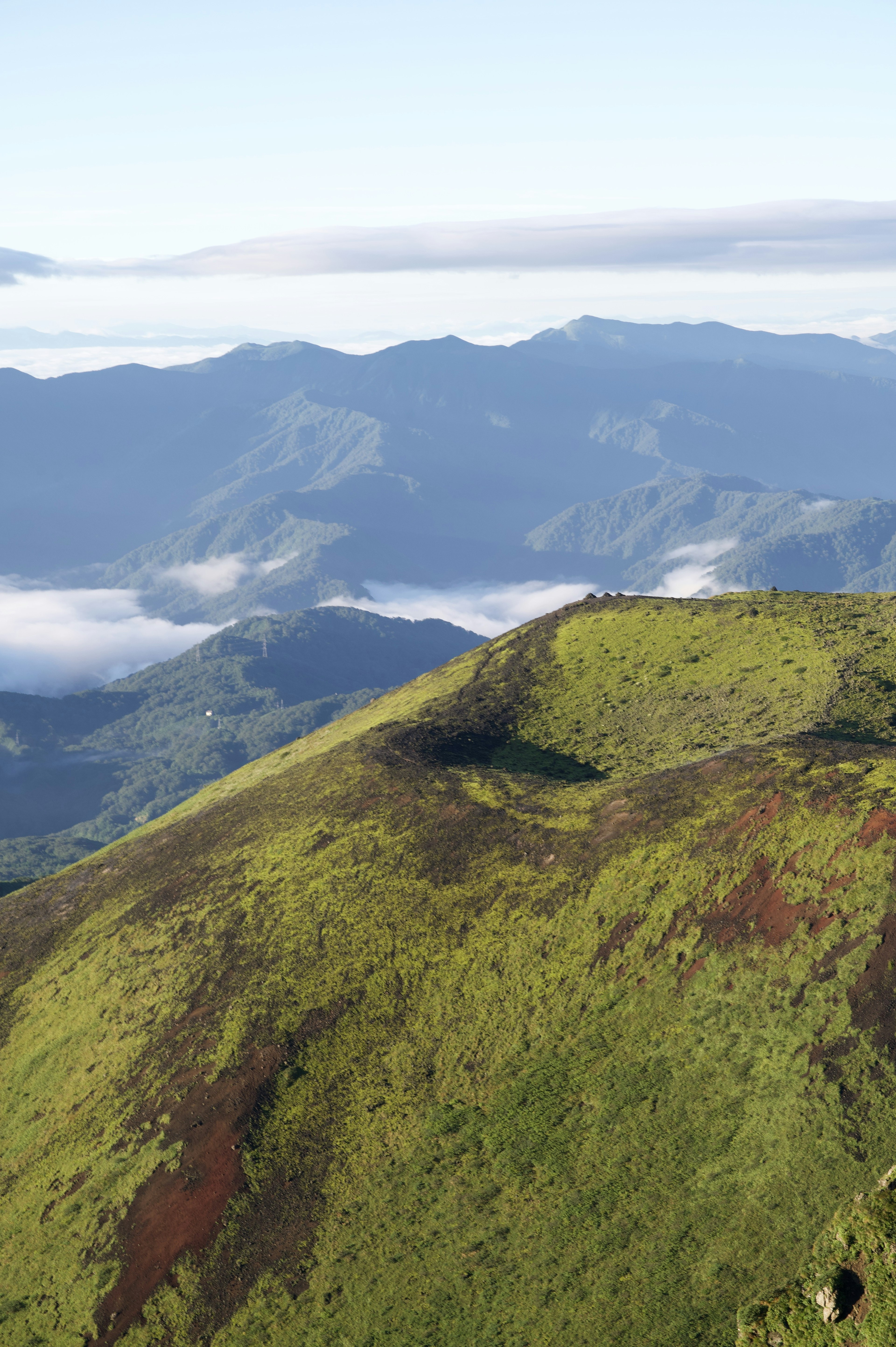 緑の草に覆われた山の景色と遠くの山々