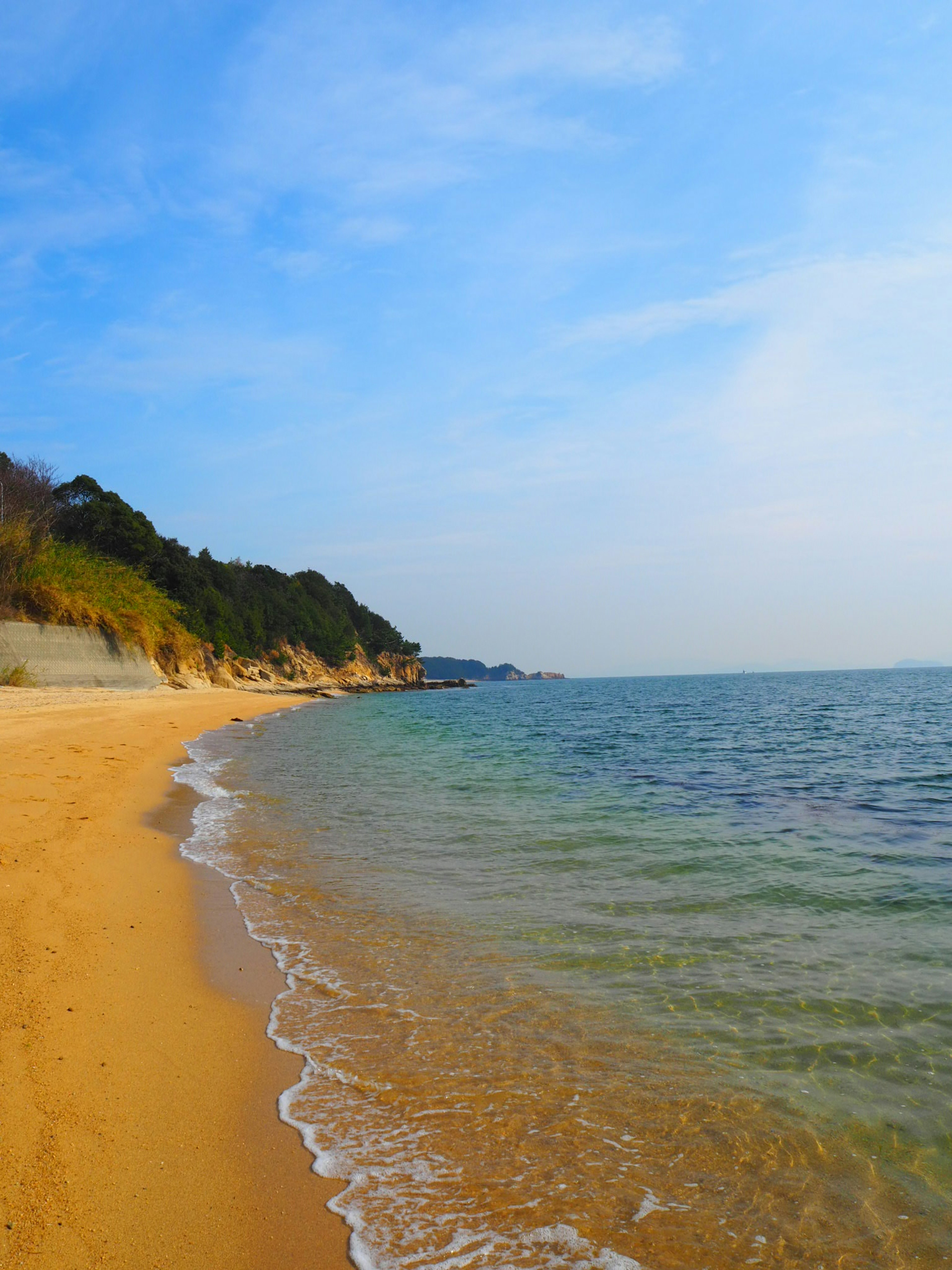 Malersicher Strandblick mit blauem Himmel und ruhigem Meer