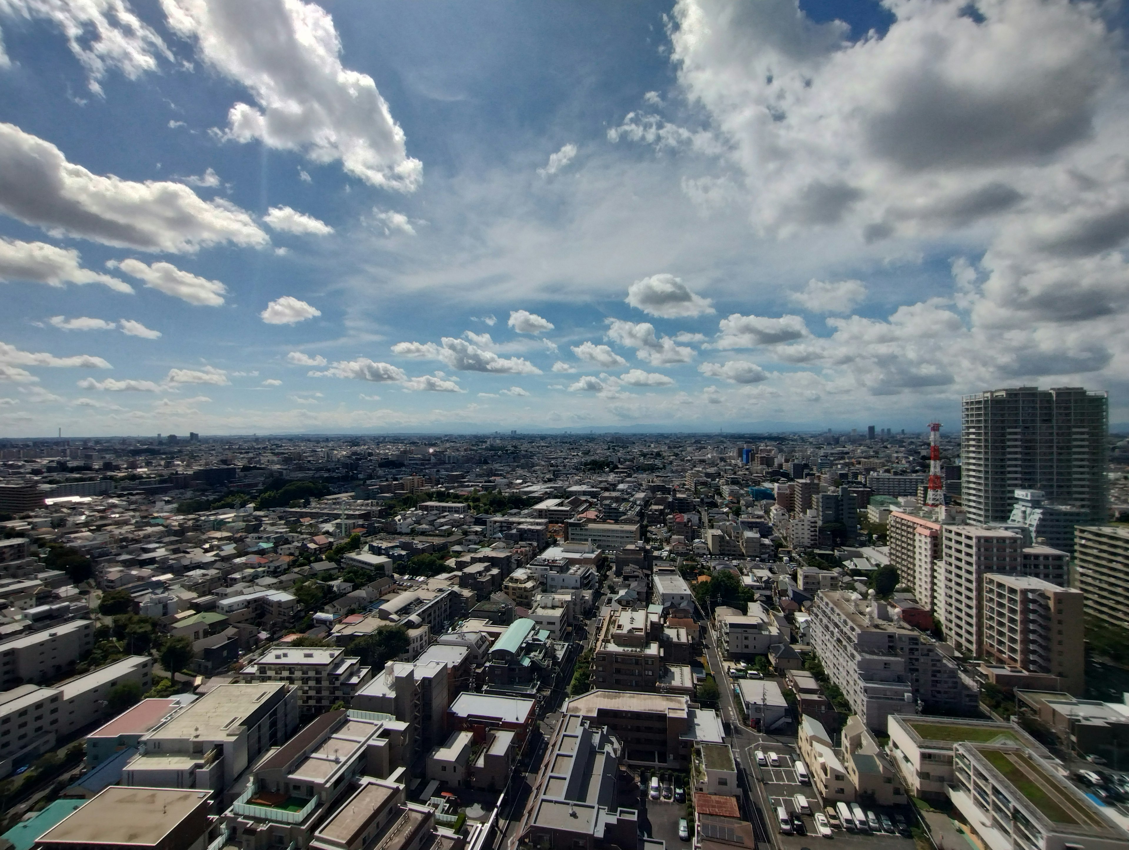 Cityscape featuring high-rise buildings and expansive blue sky