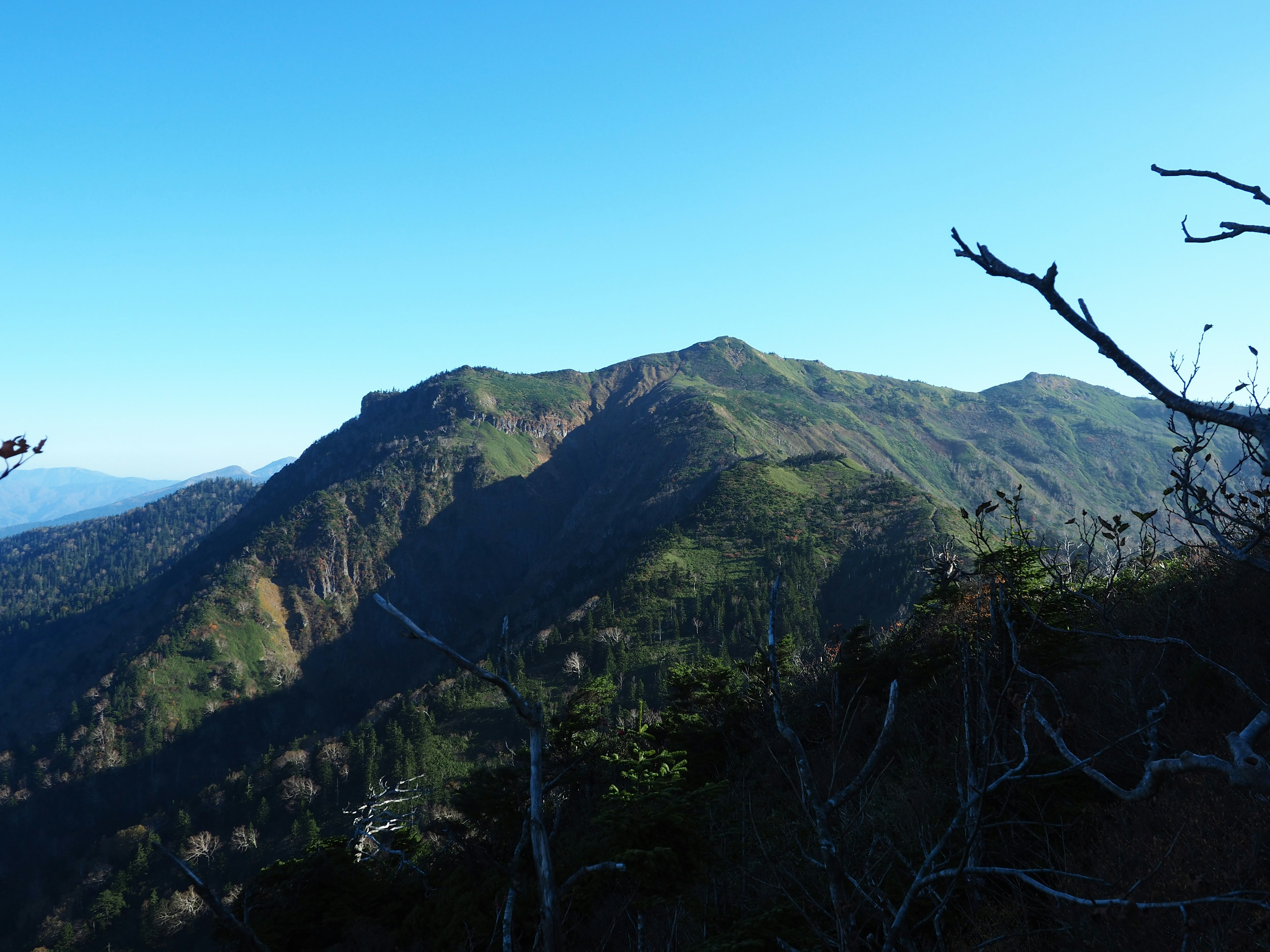 Montagnes verdoyantes sous un ciel bleu clair