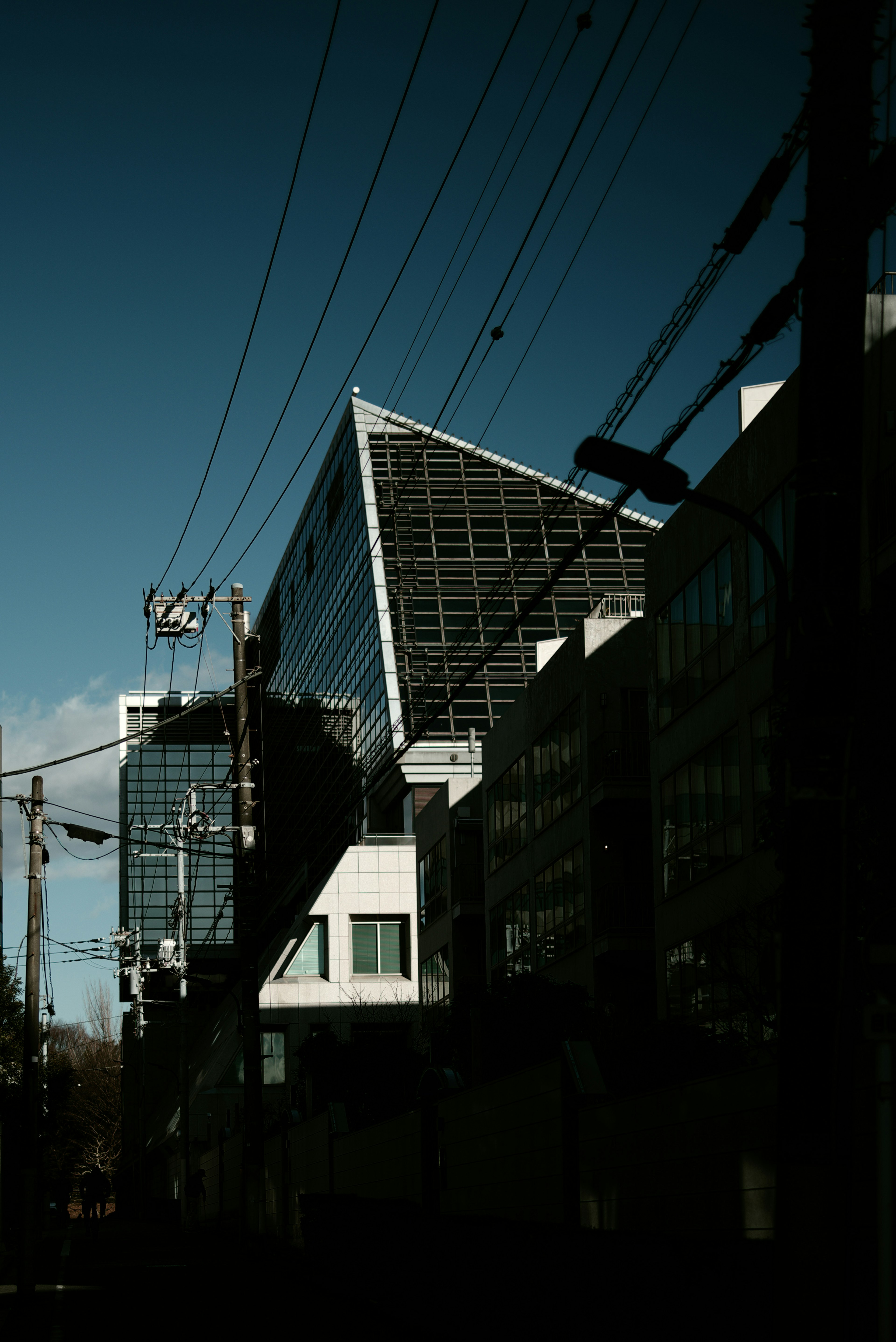 近代的な建物と電線が交差する街の風景