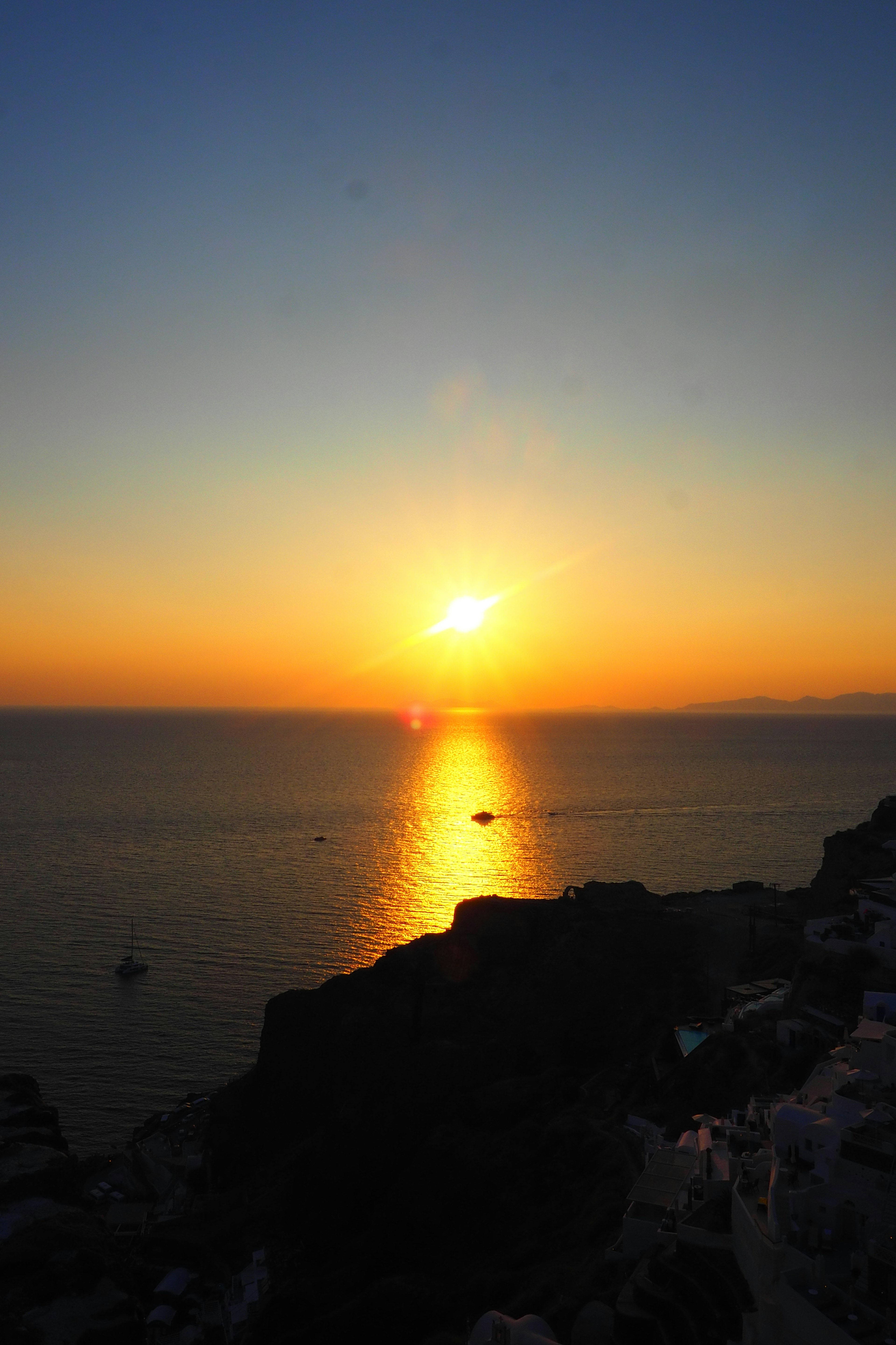 美しい夕日が海に沈む風景岩場と穏やかな海の反射