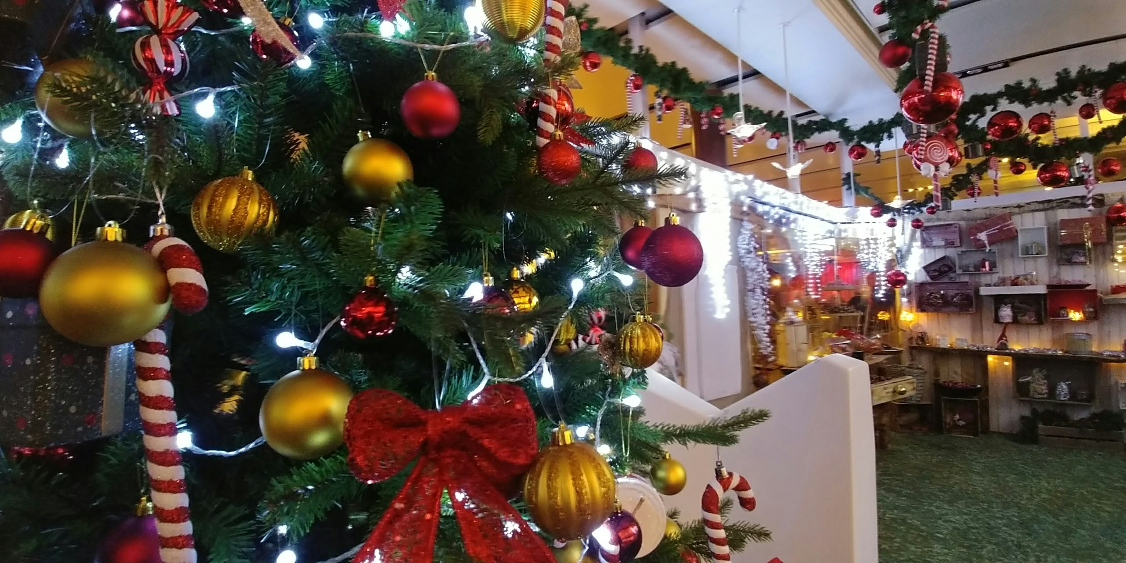 Arbre de Noël décoré avec des ornements dorés et rouges et des rubans