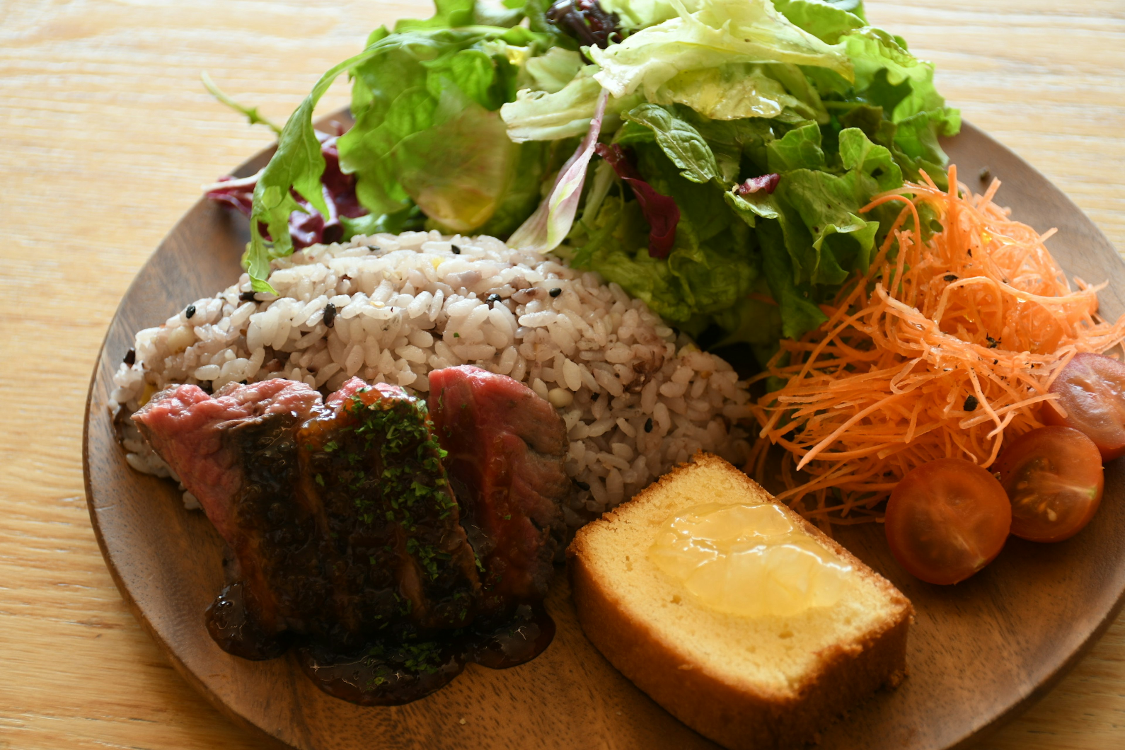 Un piatto con insalata colorata, riso, piatto di carne e dessert