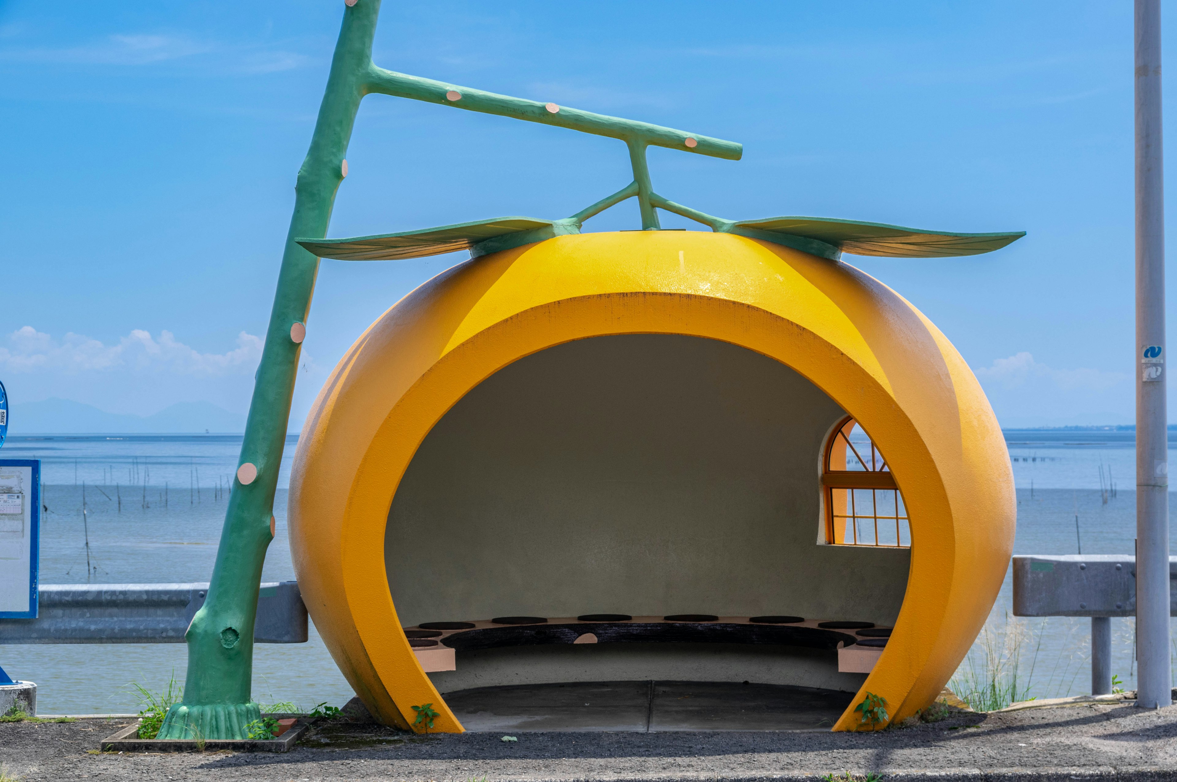 Fermata dell'autobus a forma di arancia vicino al mare