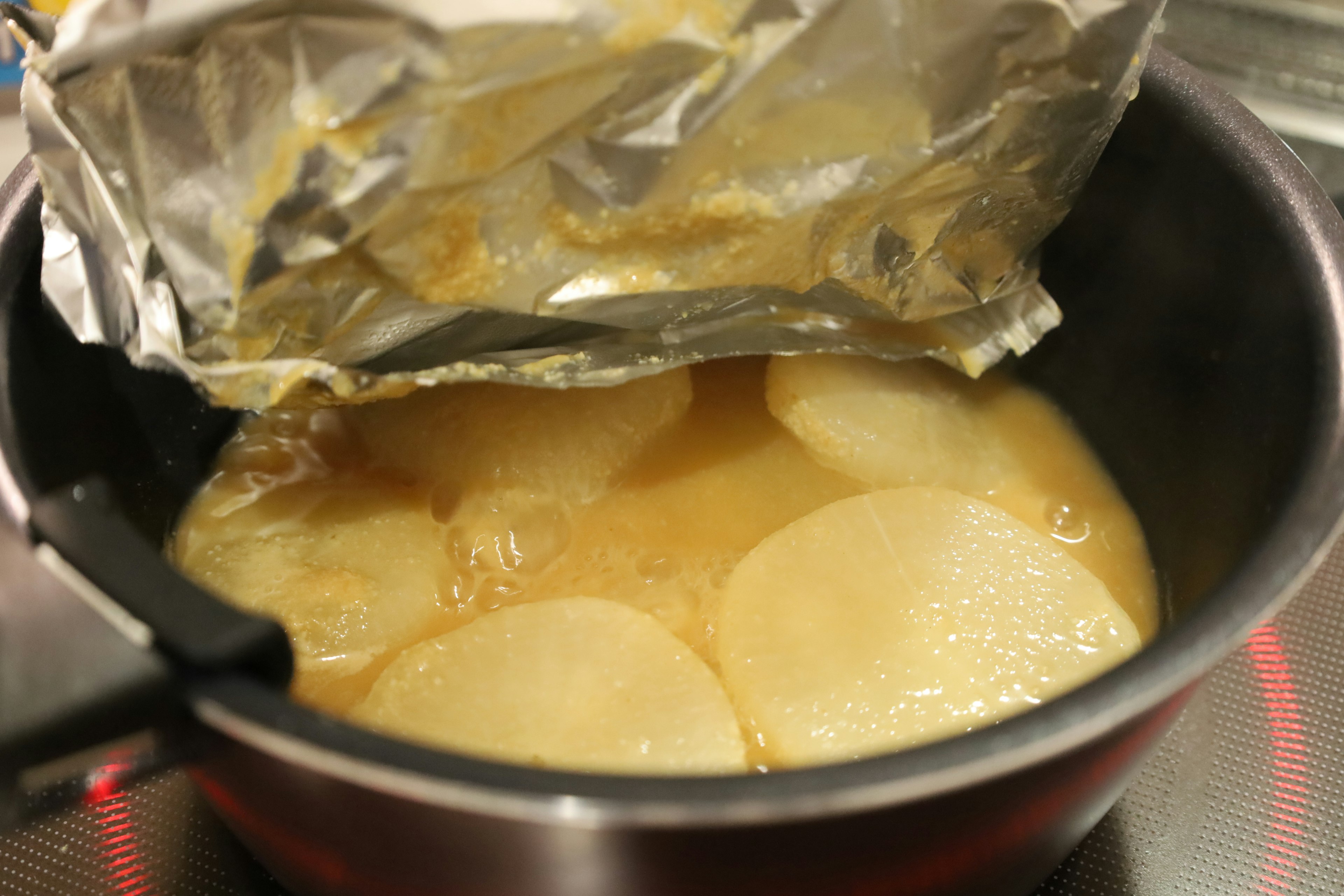 Imagen de papas redondas en una olla con caldo claro