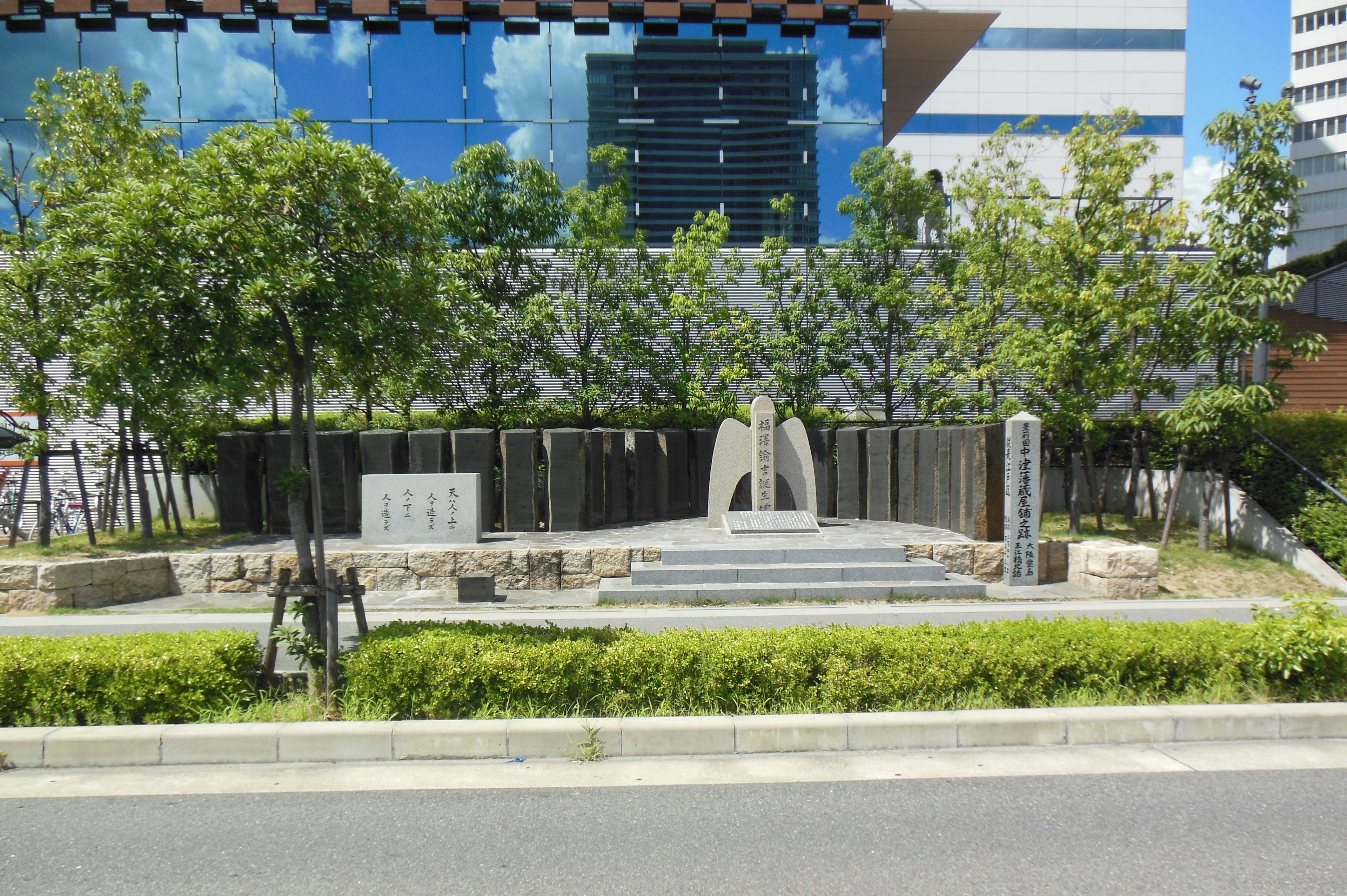 Taman modern dengan patung di depan gedung kontemporer