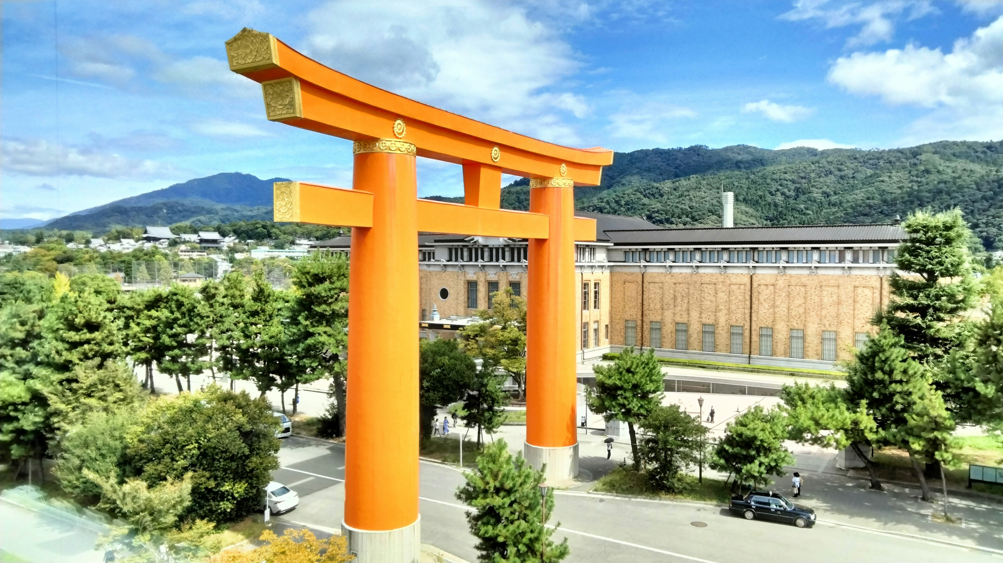 大きなオレンジ色の鳥居と背景に山が見える風景