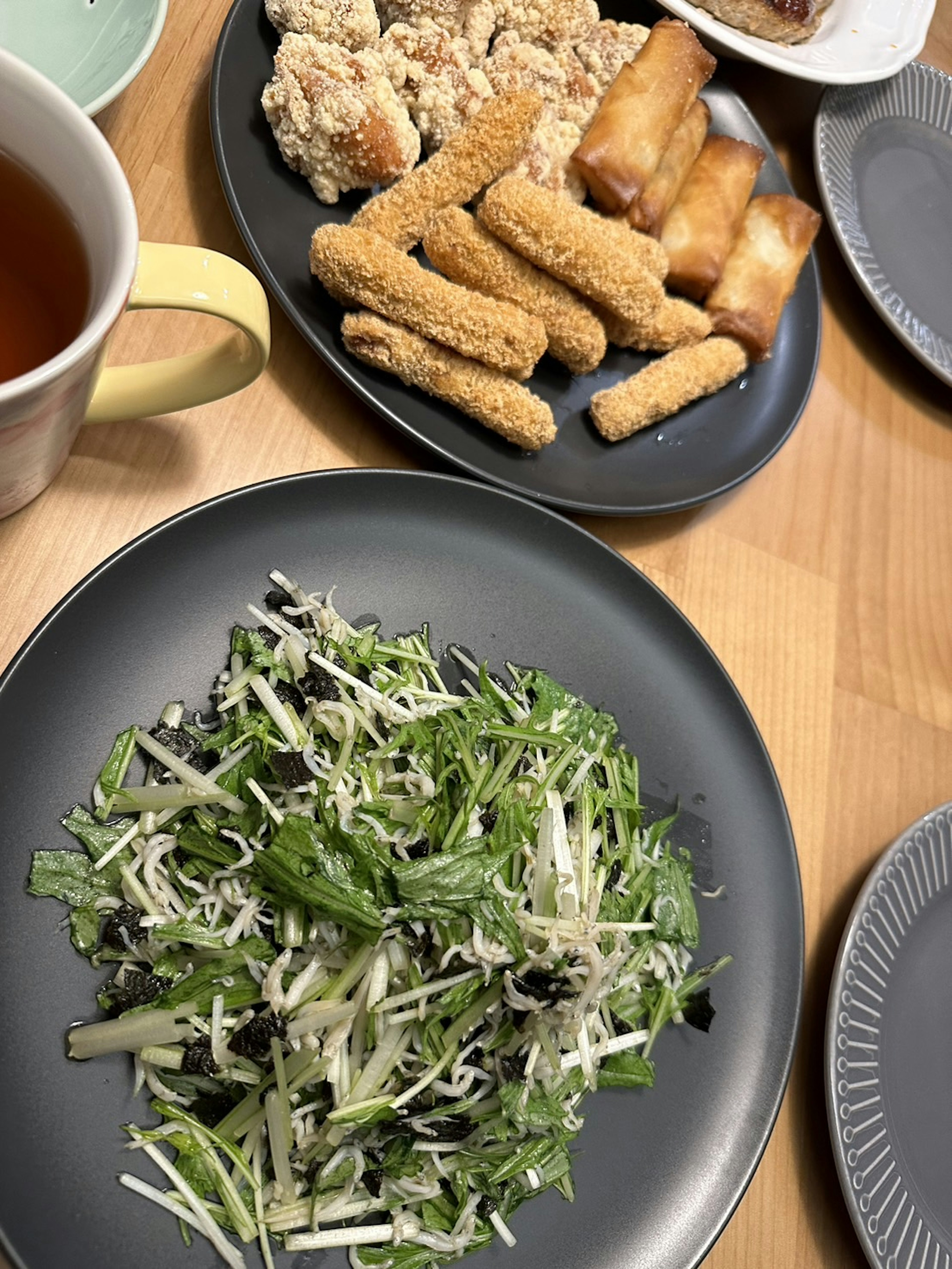 Un tavolo con un'insalata di verdure fresche e un assortimento di cibi fritti