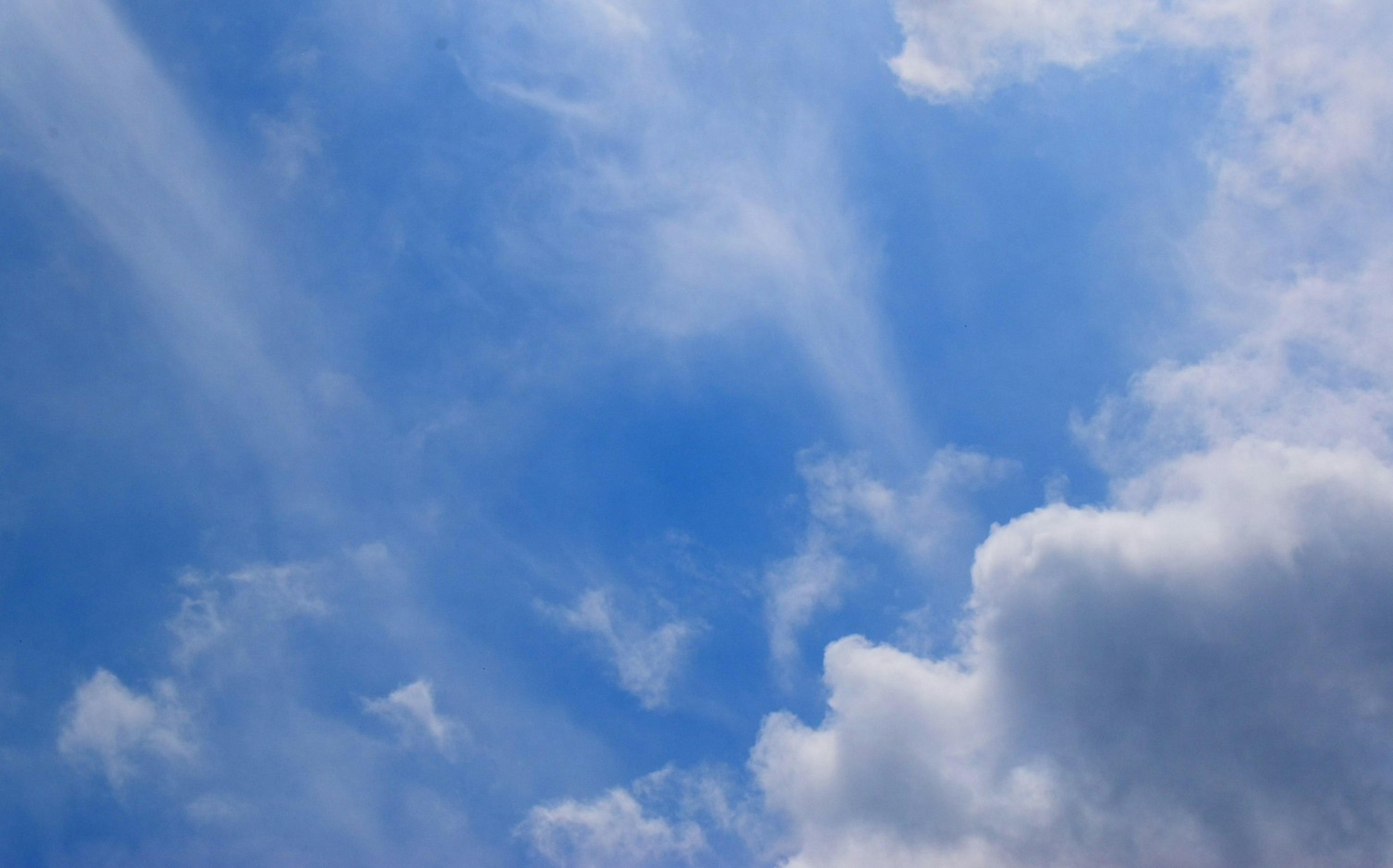 Un ciel bleu lumineux avec des nuages blancs duveteux