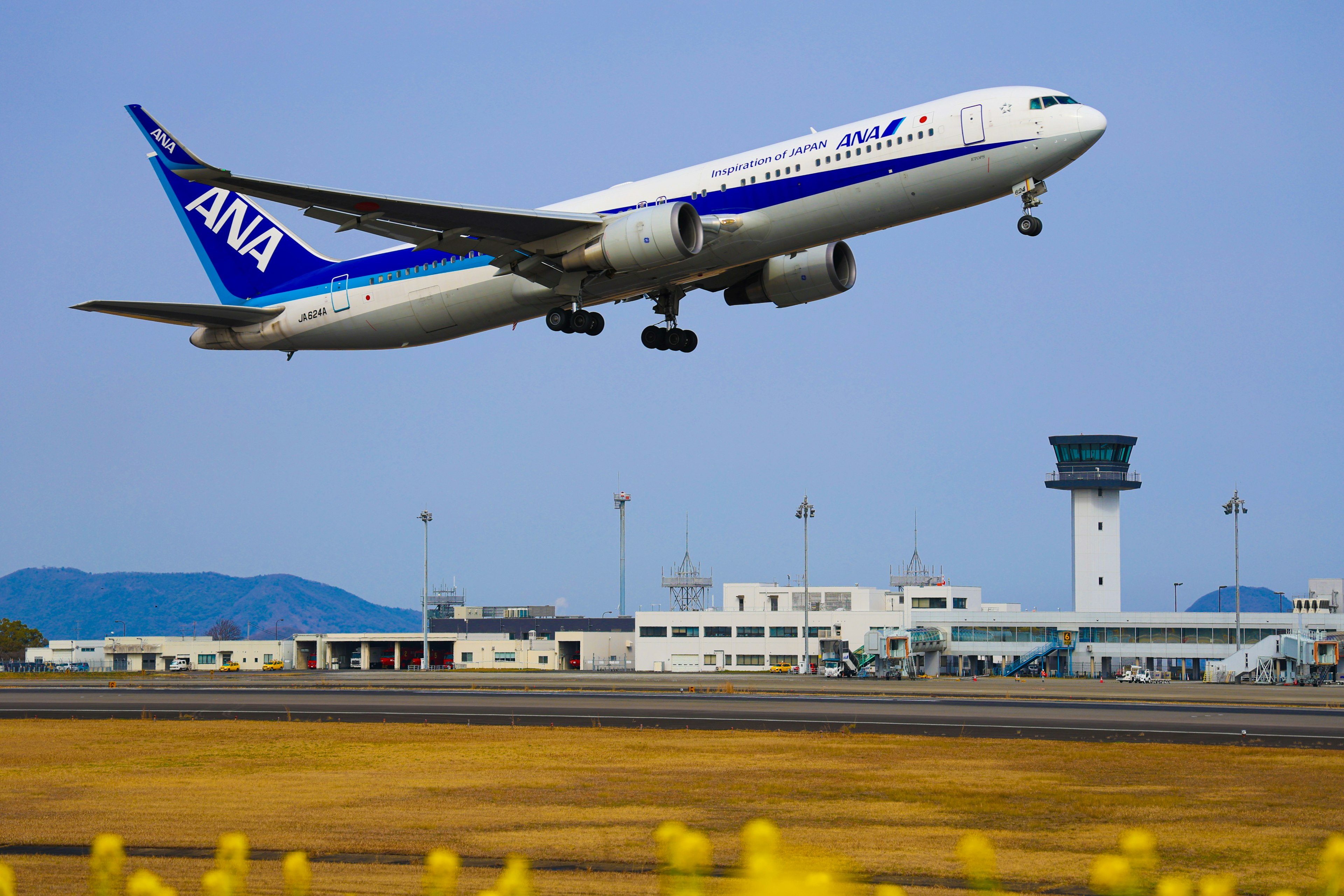 ANA-Flugzeug startet vor klarem blauen Himmel