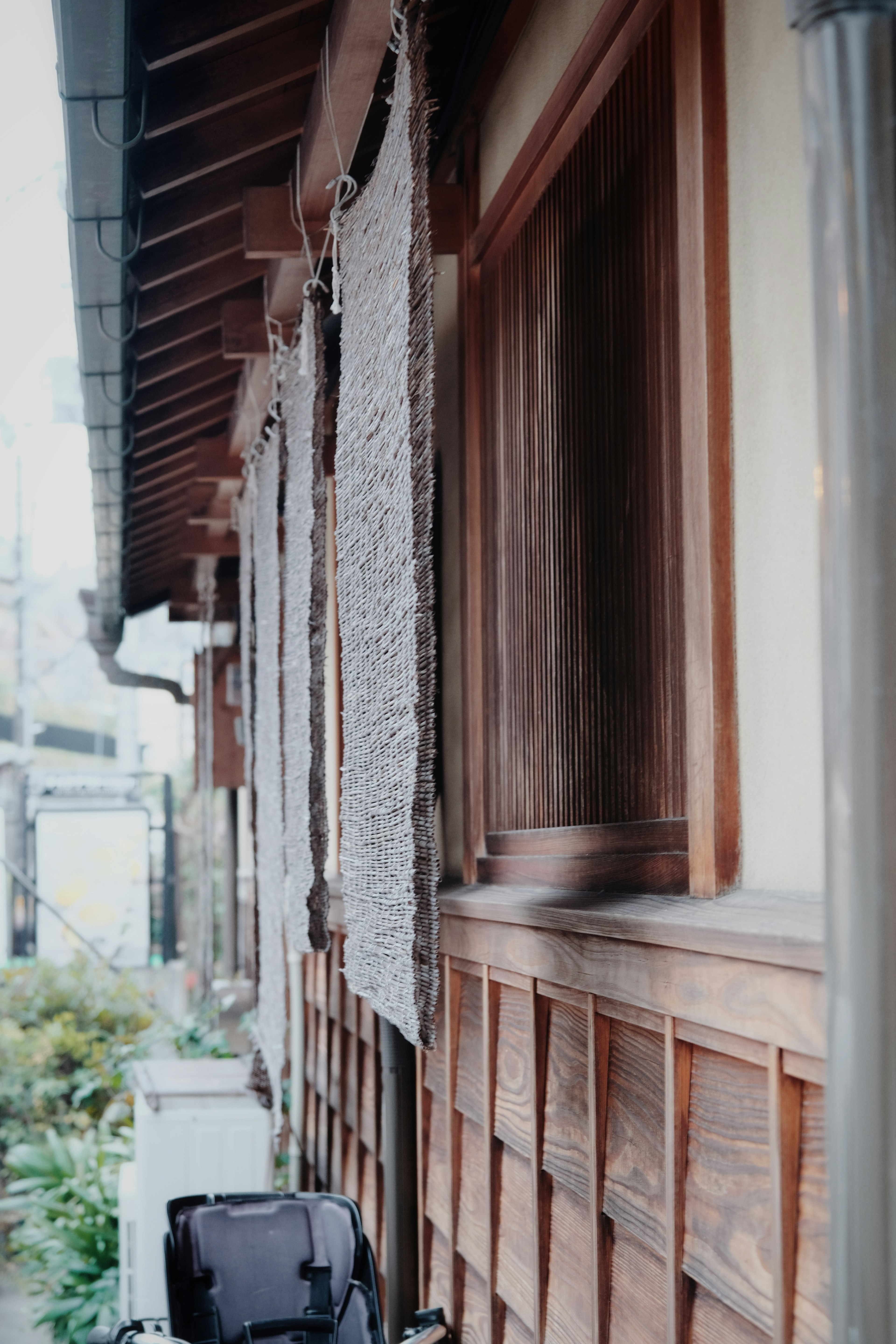 Traditional wooden Japanese house exterior with fabric hanging near the window