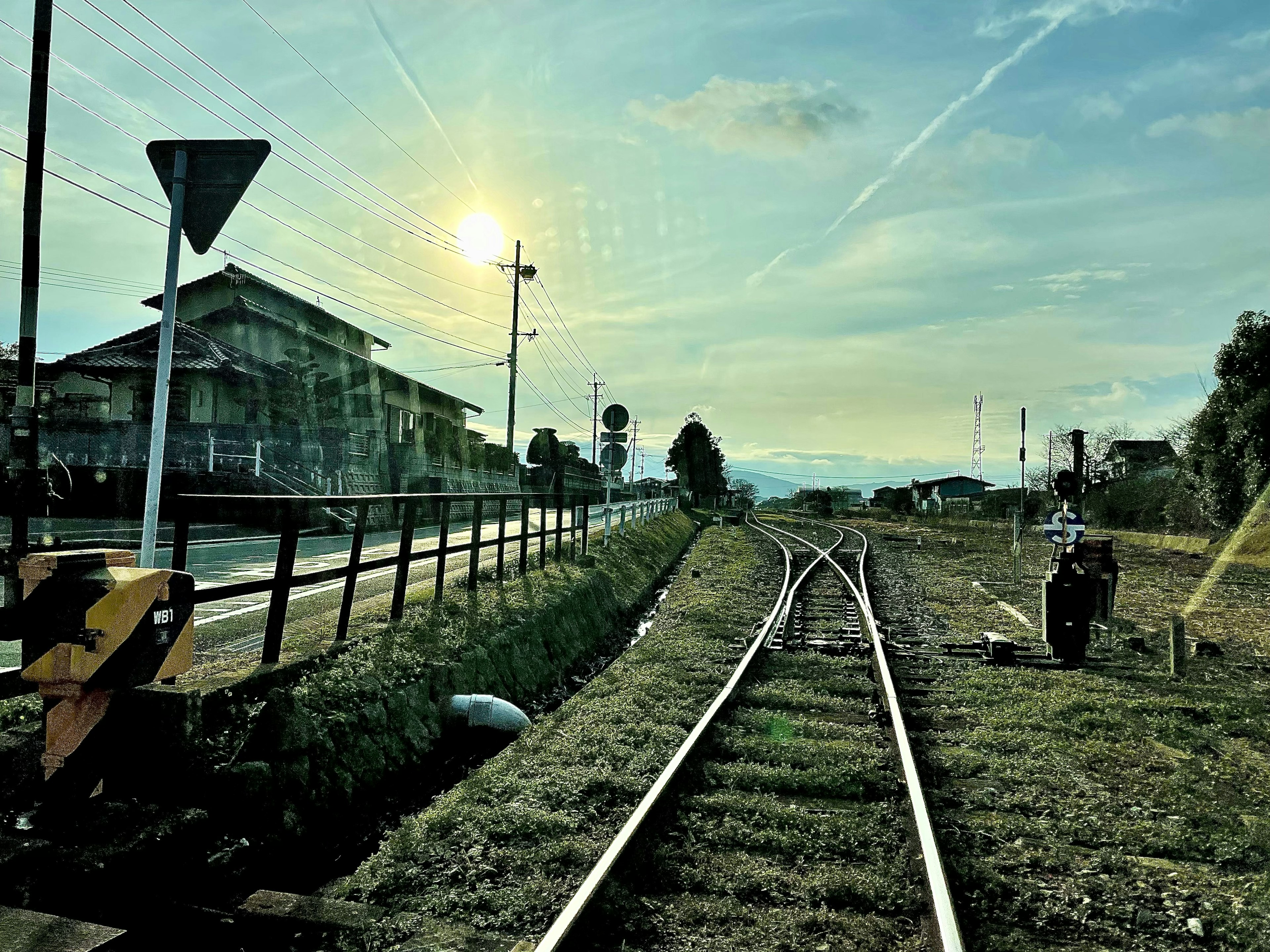 Vista escénica de vías de tren con atardecer y edificios