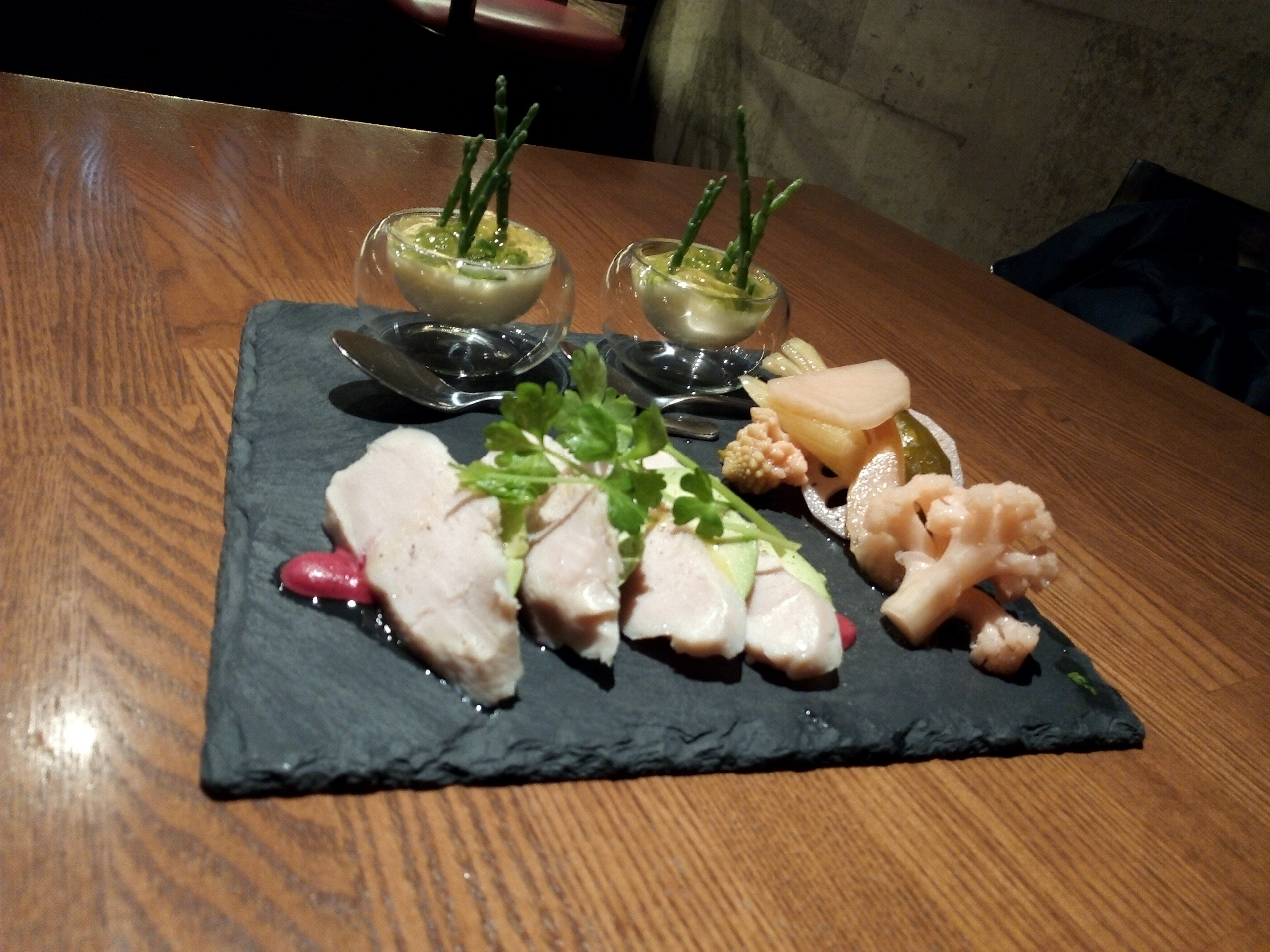 Fresh fish and vegetables elegantly arranged on a black stone plate