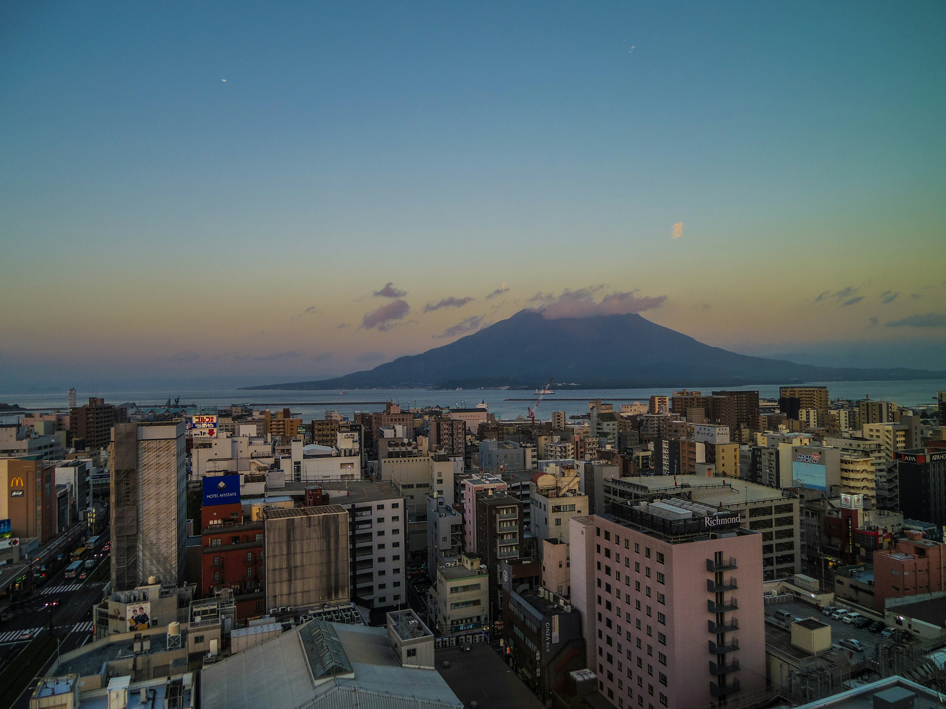 Paisaje urbano de Kagoshima al atardecer con la montaña Sakurajima