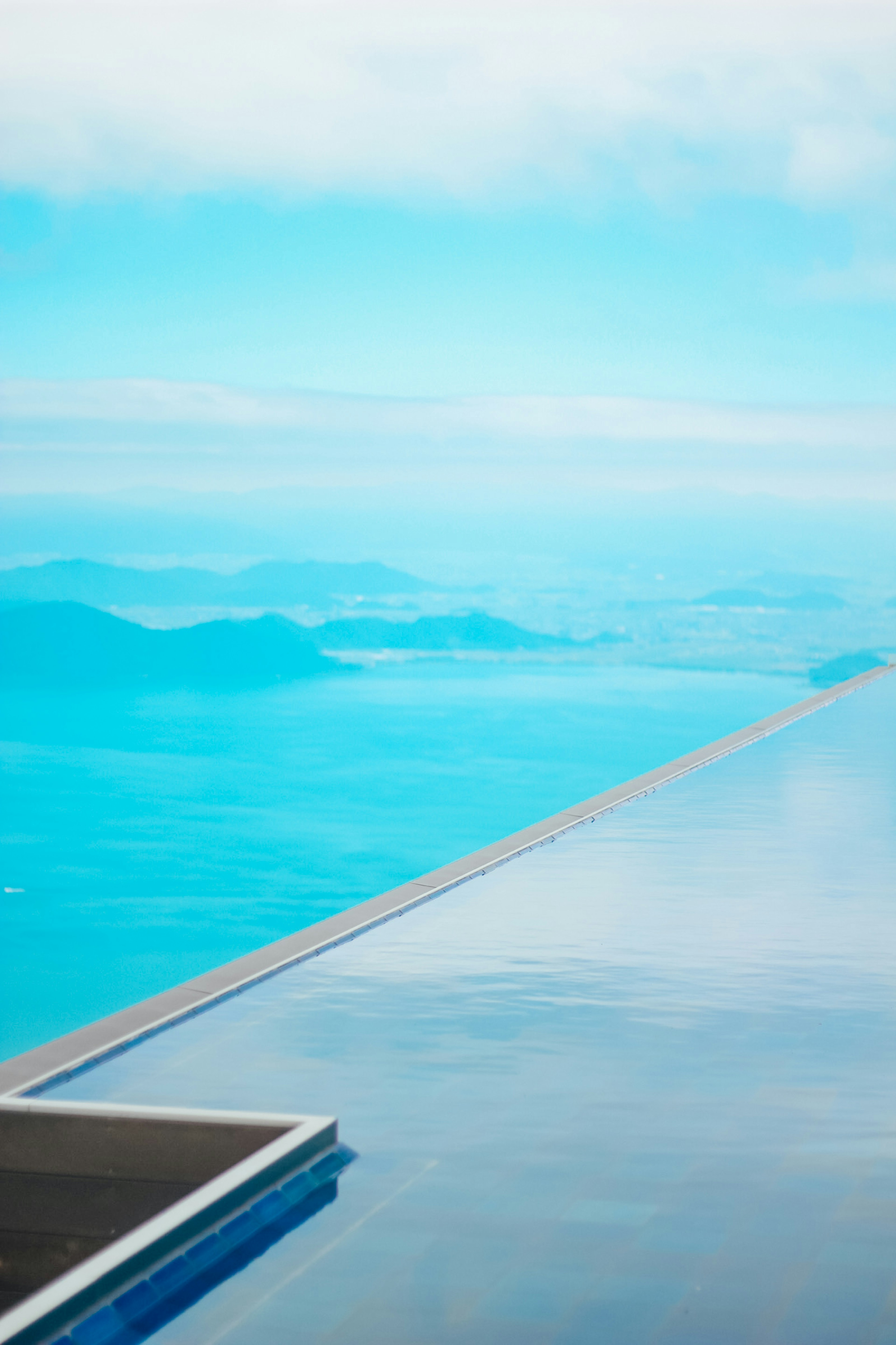 Vue panoramique du ciel bleu et de l'océan avec une section d'une piscine à débordement