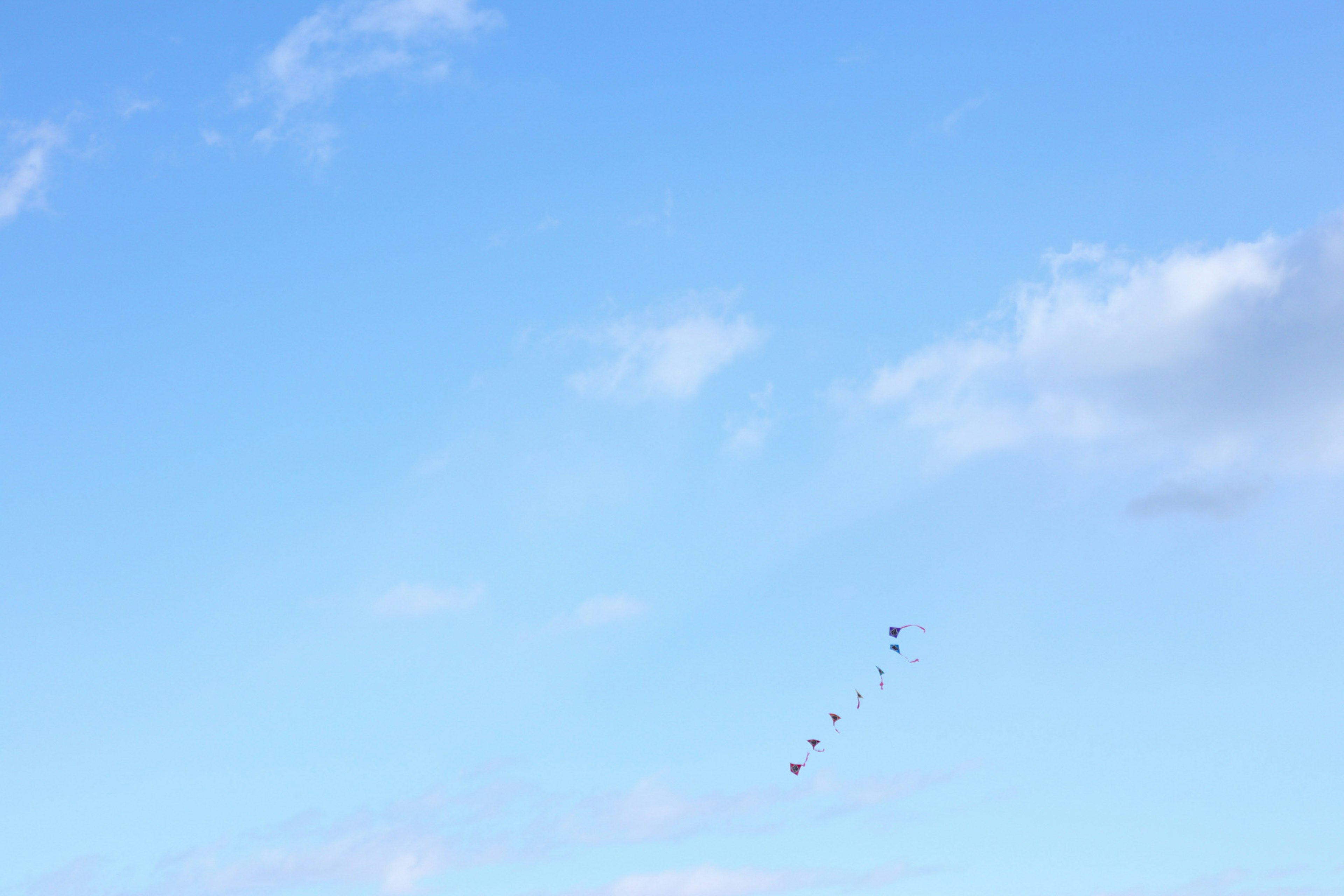 Drachen fliegt in einem klaren blauen Himmel mit dünnen Wolken