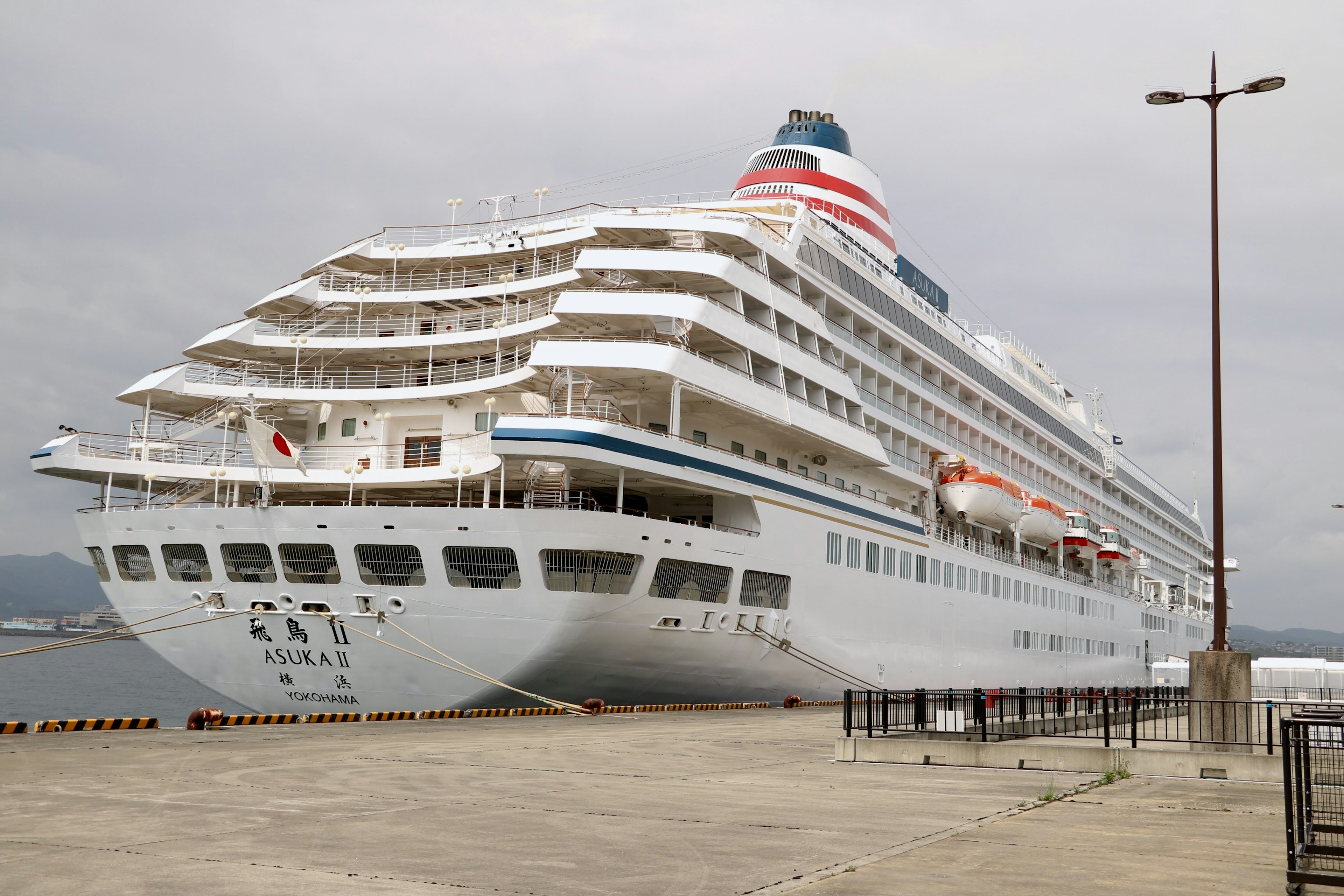 A large white cruise ship docked at the harbor