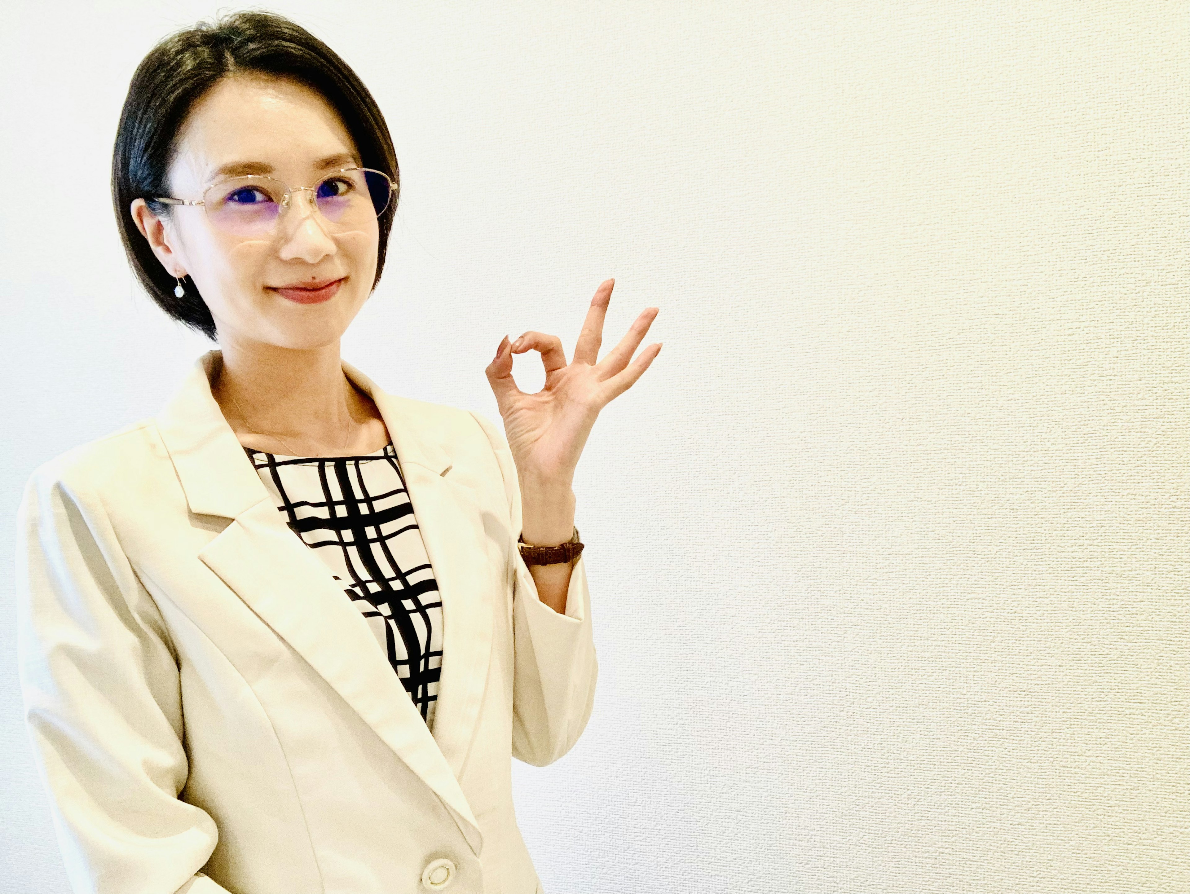 Businesswoman posing with a hand gesture against a white background