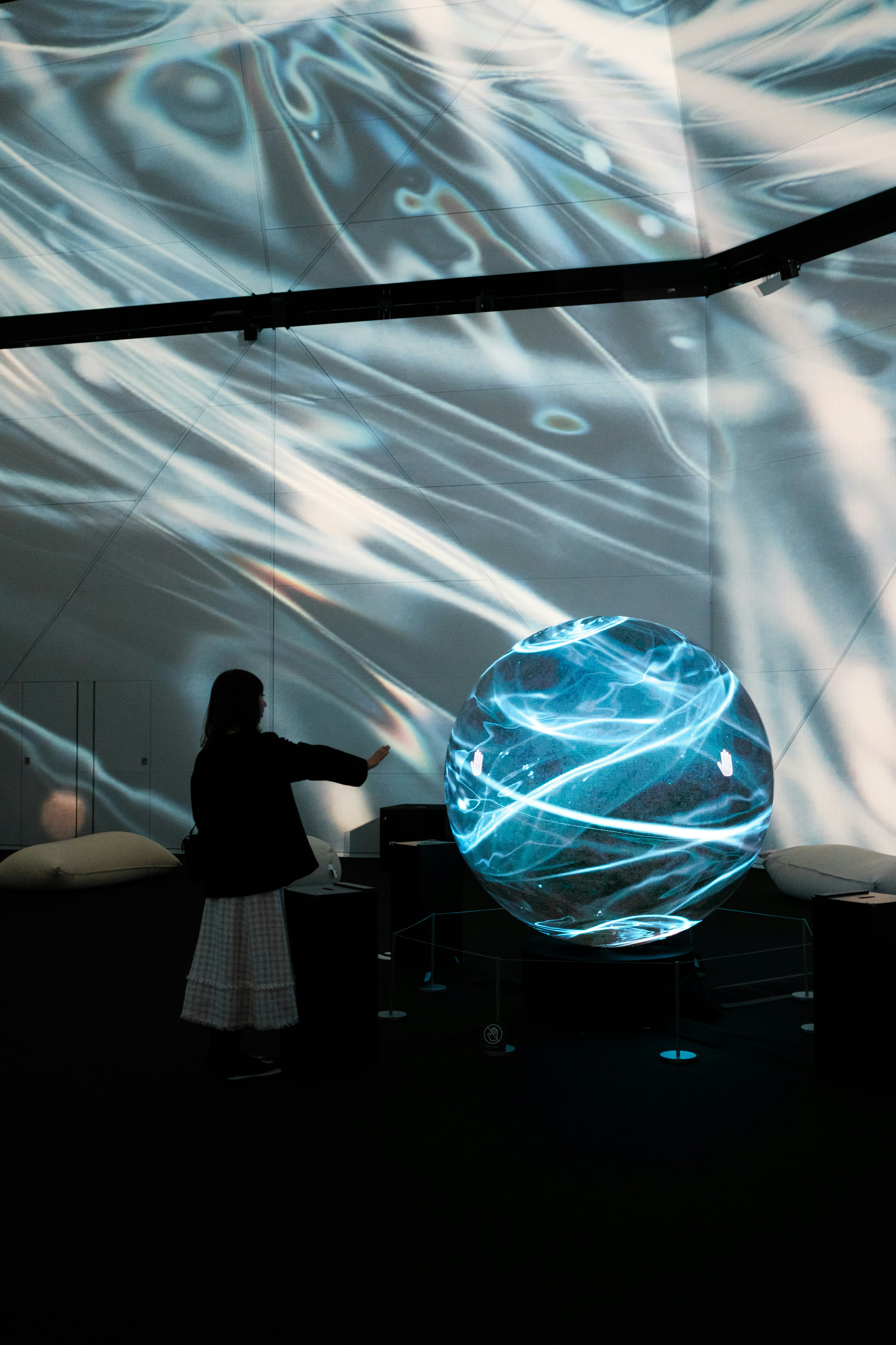 Persona extendiendo la mano hacia una esfera azul brillante contra un fondo dinámico