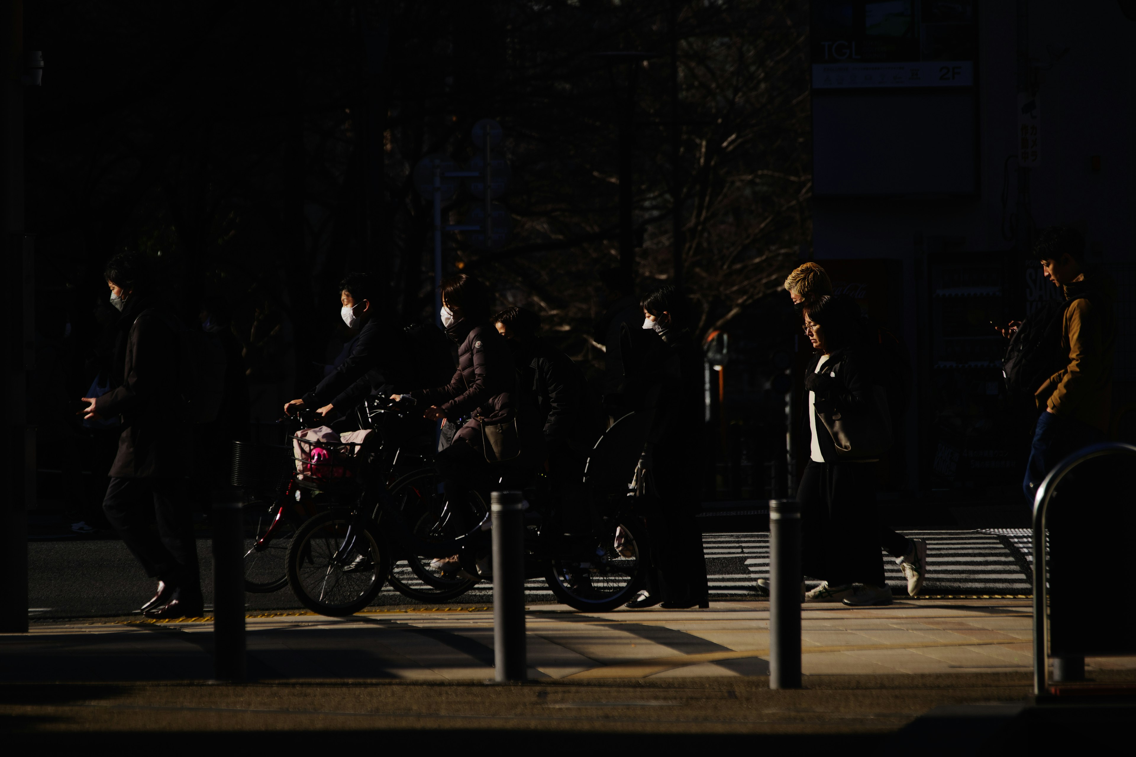 Des personnes marchant et faisant du vélo dans un cadre urbain sombre