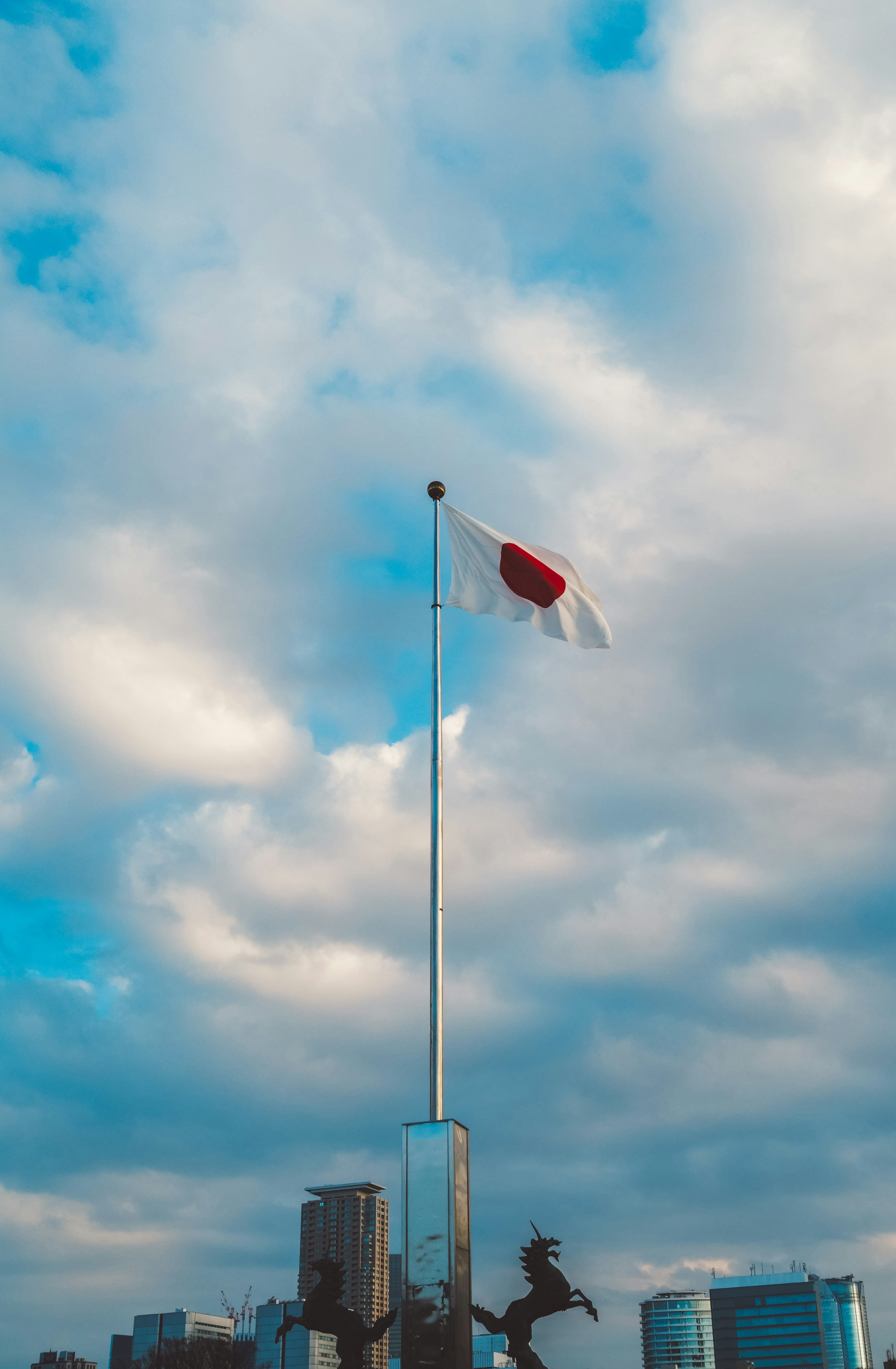 日本国旗在蓝天和云朵的背景下飘扬