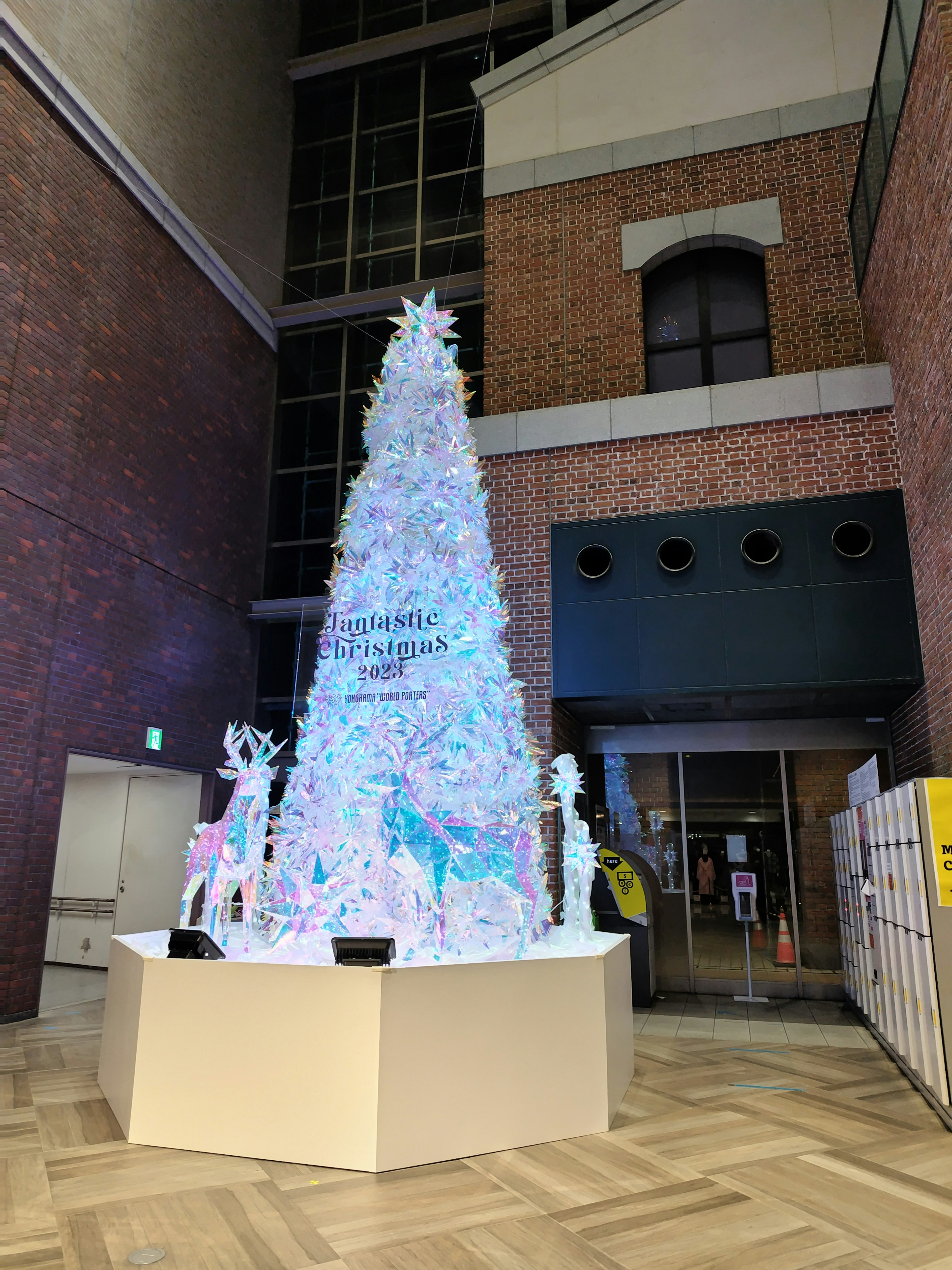 Un albero di Natale bianco decorato con luci colorate in un ambiente interno