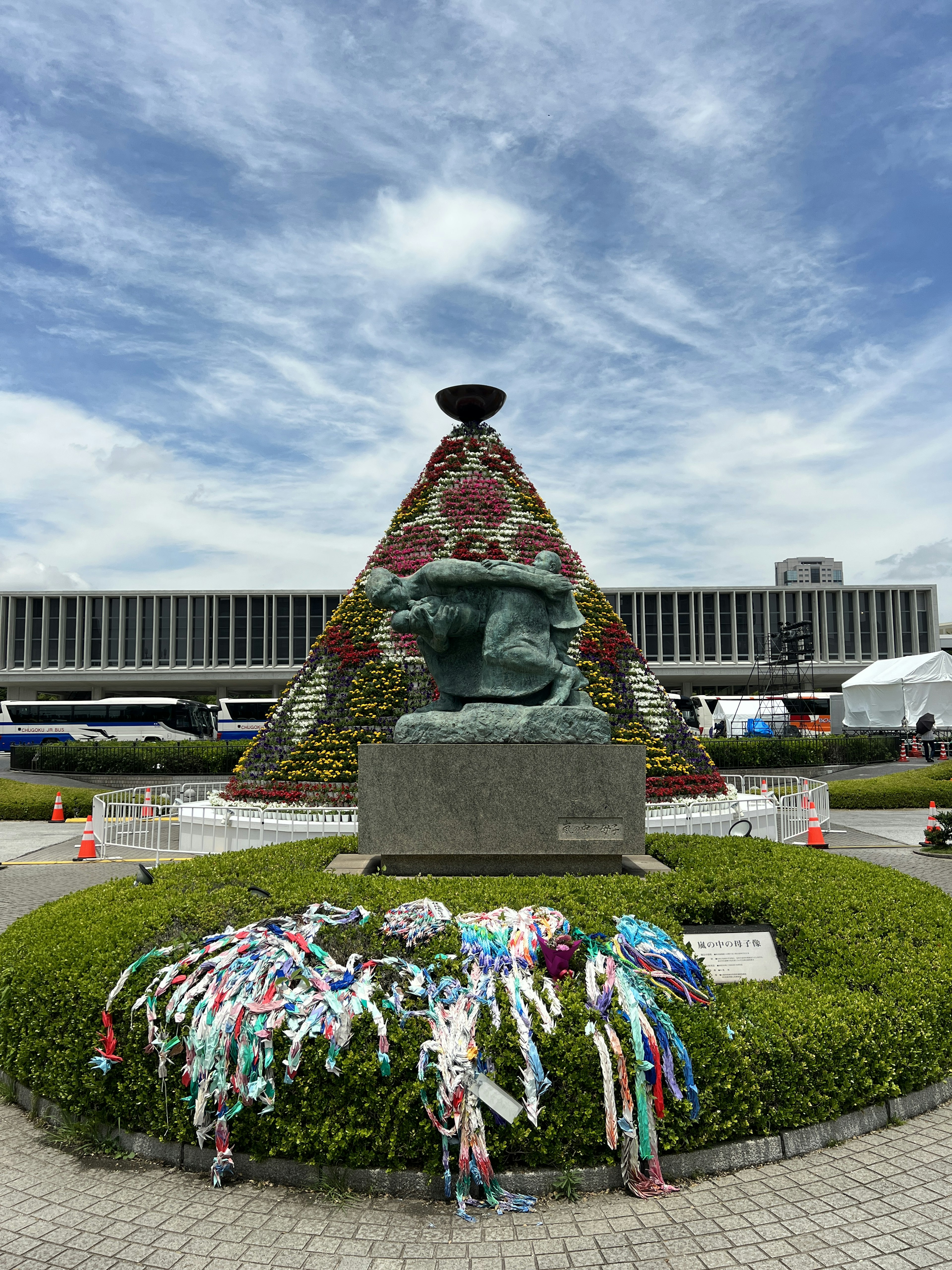 Monument decorated with flowers surrounded by colorful ribbons