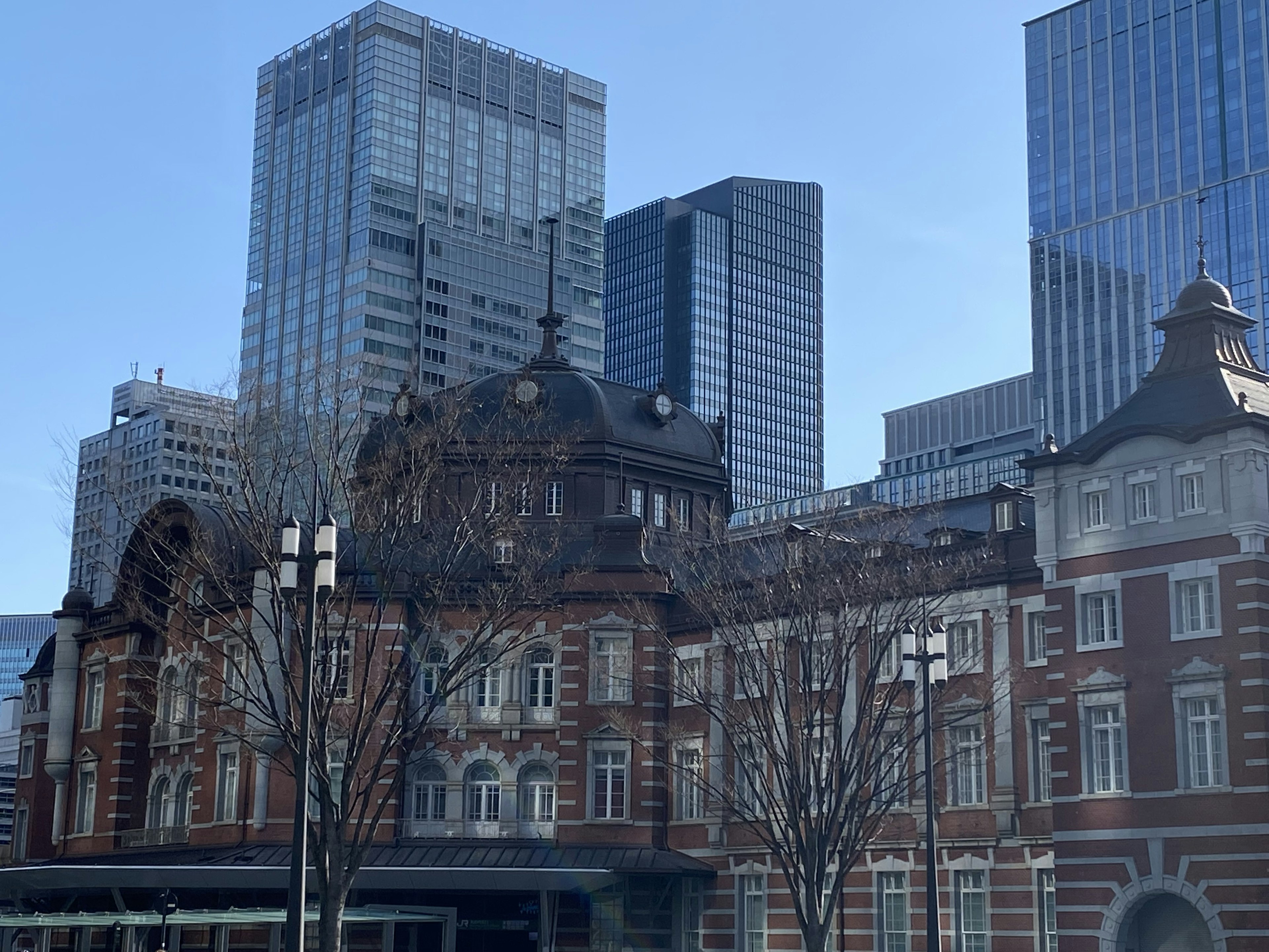 Kontrast zwischen dem historischen Gebäude des Bahnhofs Tokio und modernen Wolkenkratzern