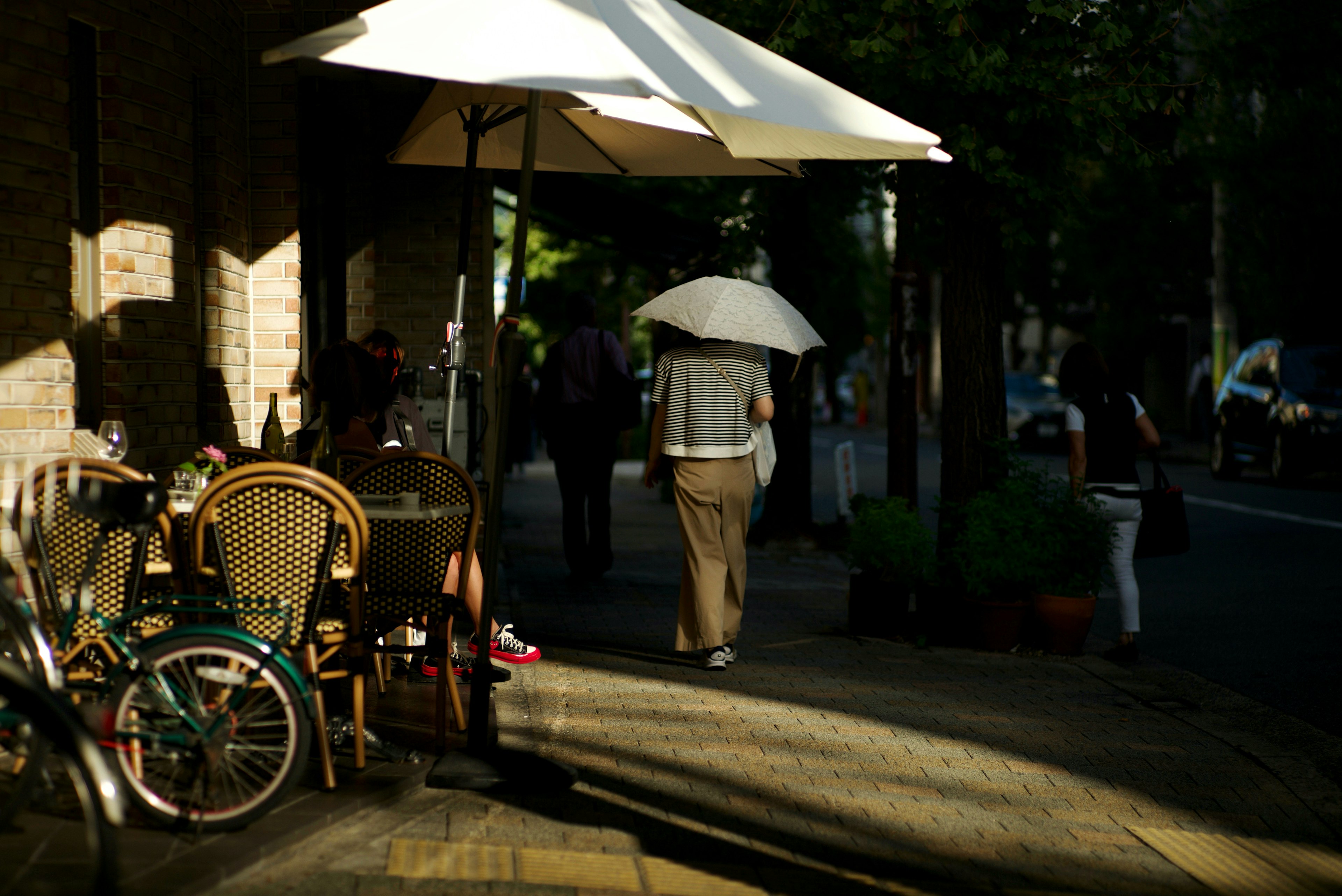 Une personne marchant avec un parasol dans un cadre de terrasse de café