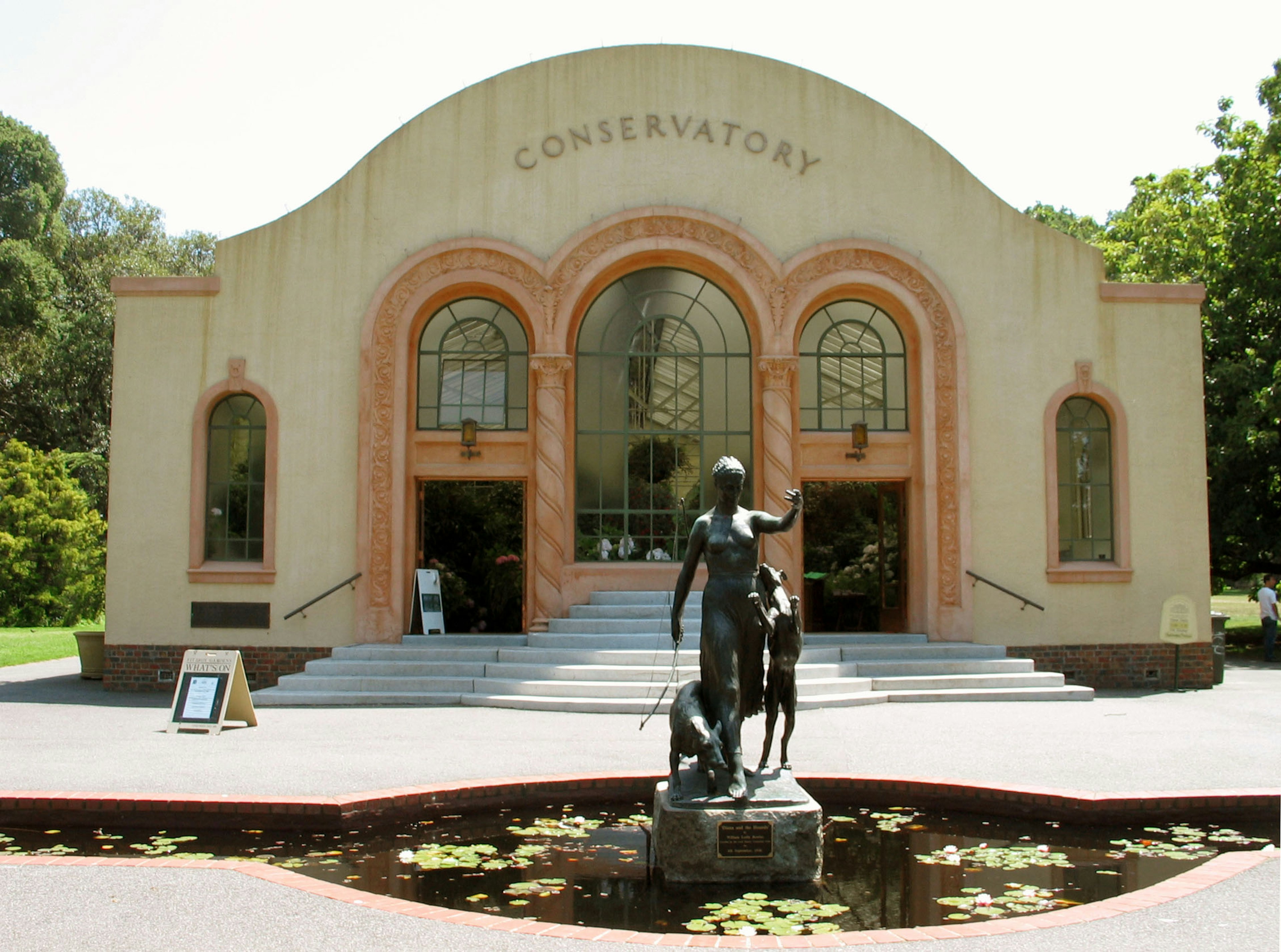 Exterior view of the Conservatory with a statue and garden setting