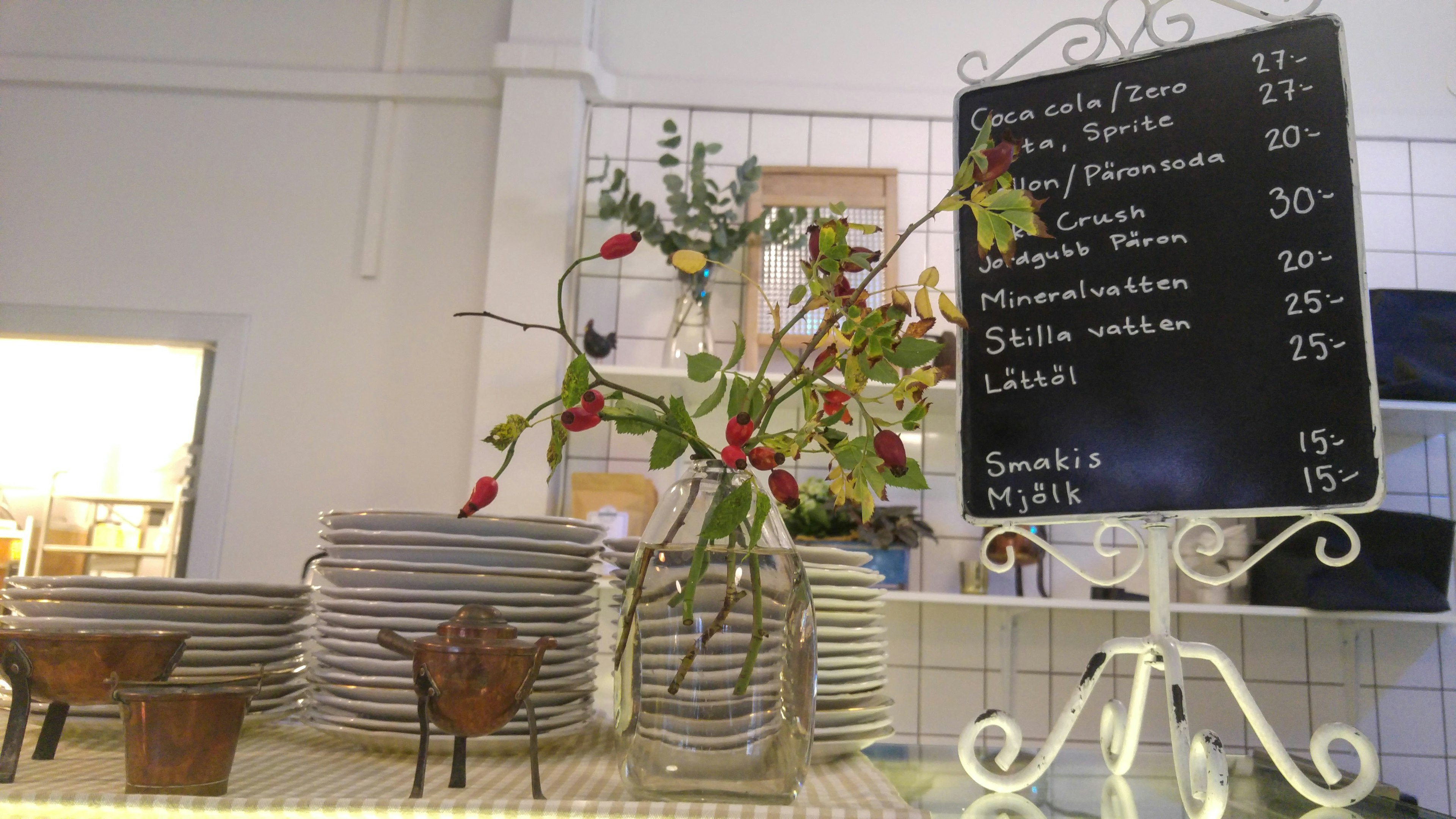 Cafe menu board with a flower vase on a table