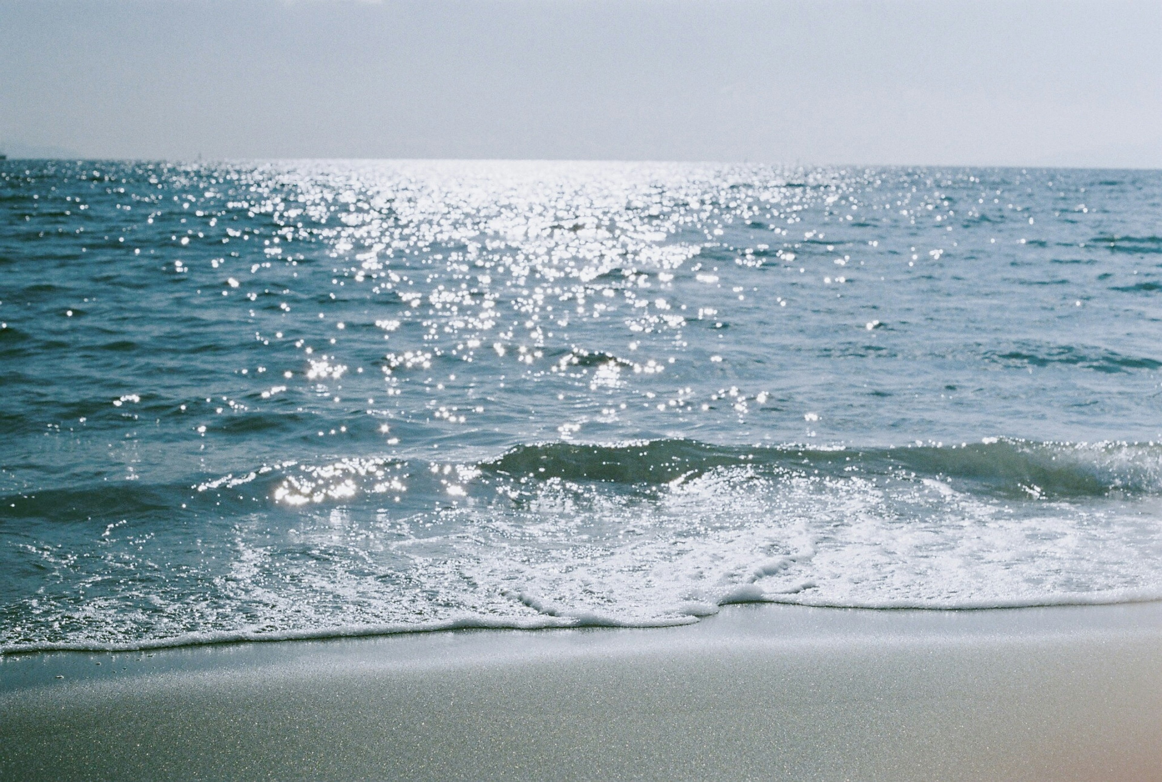 Calm ocean view gentle waves lapping against the sandy shore