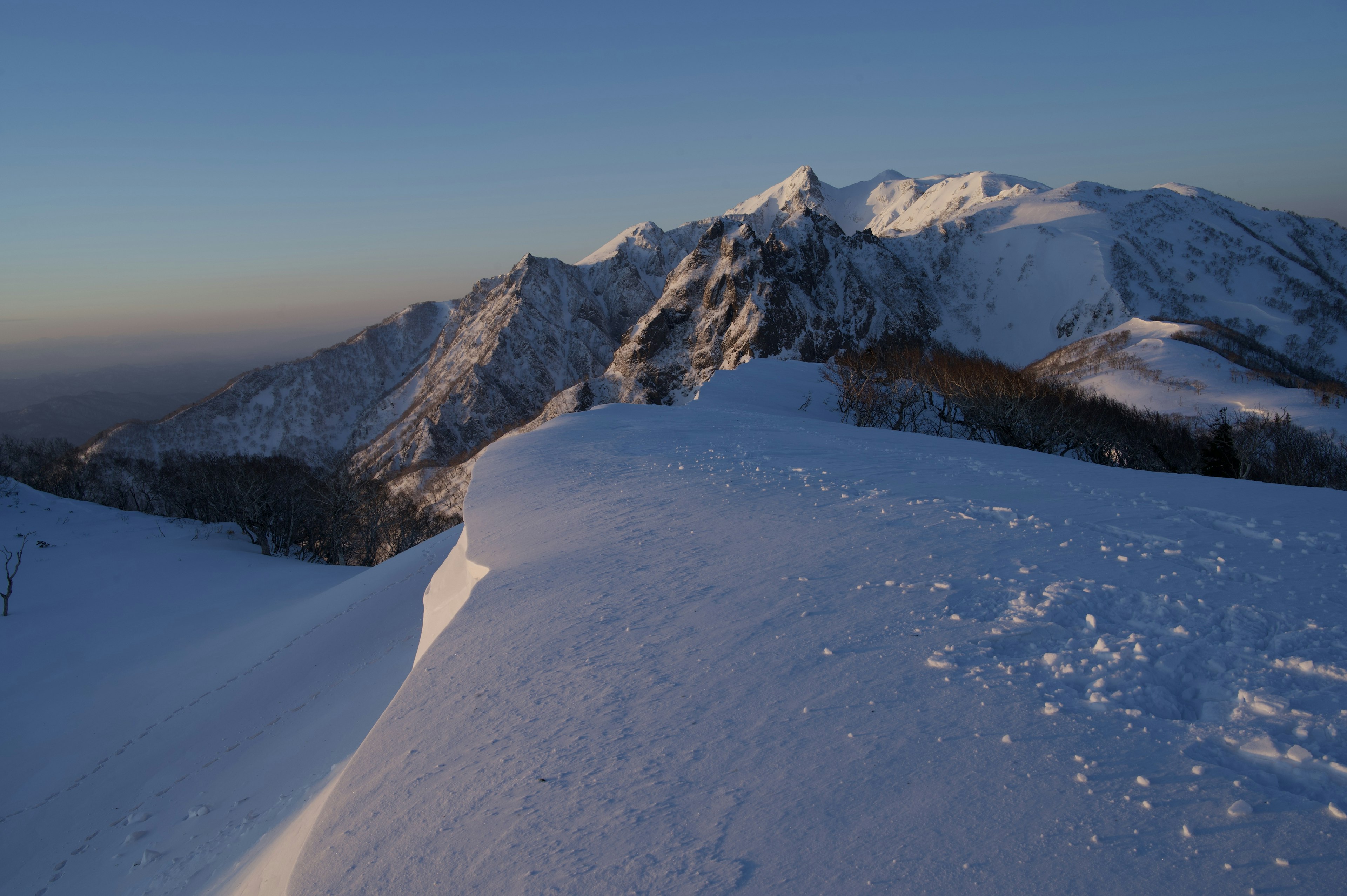 Snow-covered mountains under a clear blue sky